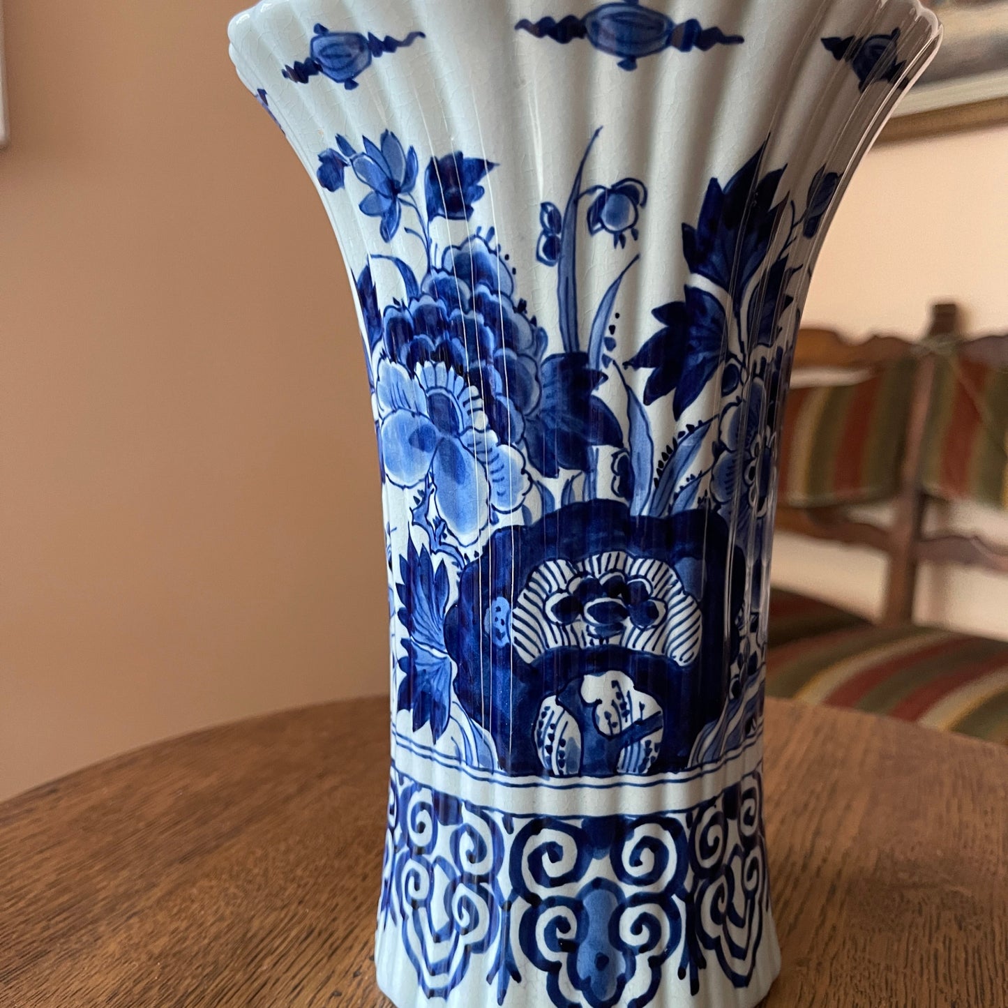 Blue and white ceramic vase with floral patterns on a wooden table.