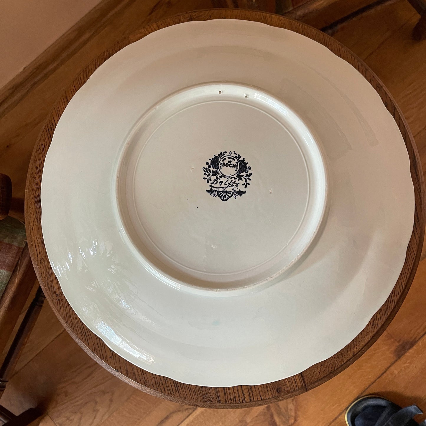 White ceramic plate with a black logo on a wooden surface