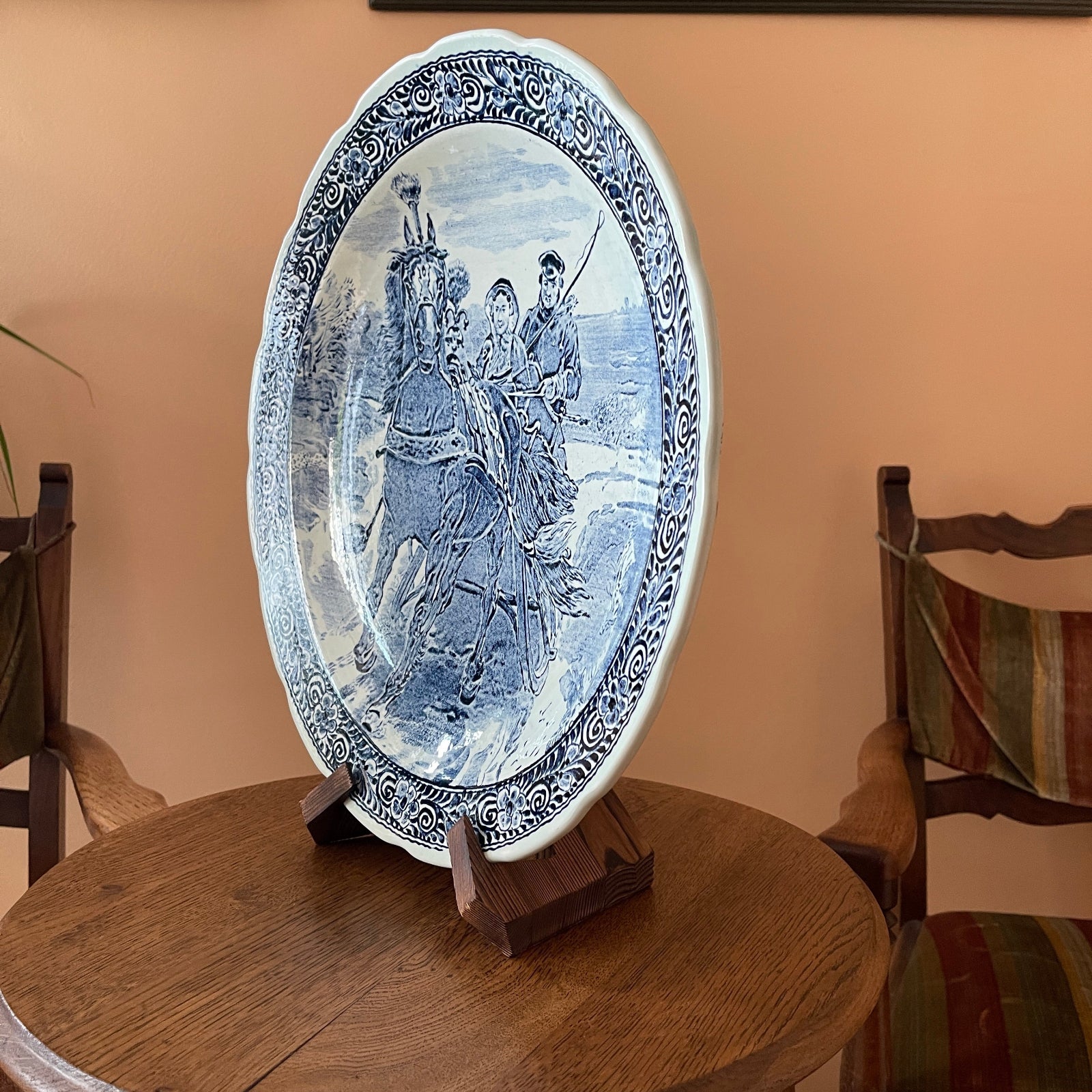 Decorative plate with artistic design on a stand against a beige wall.