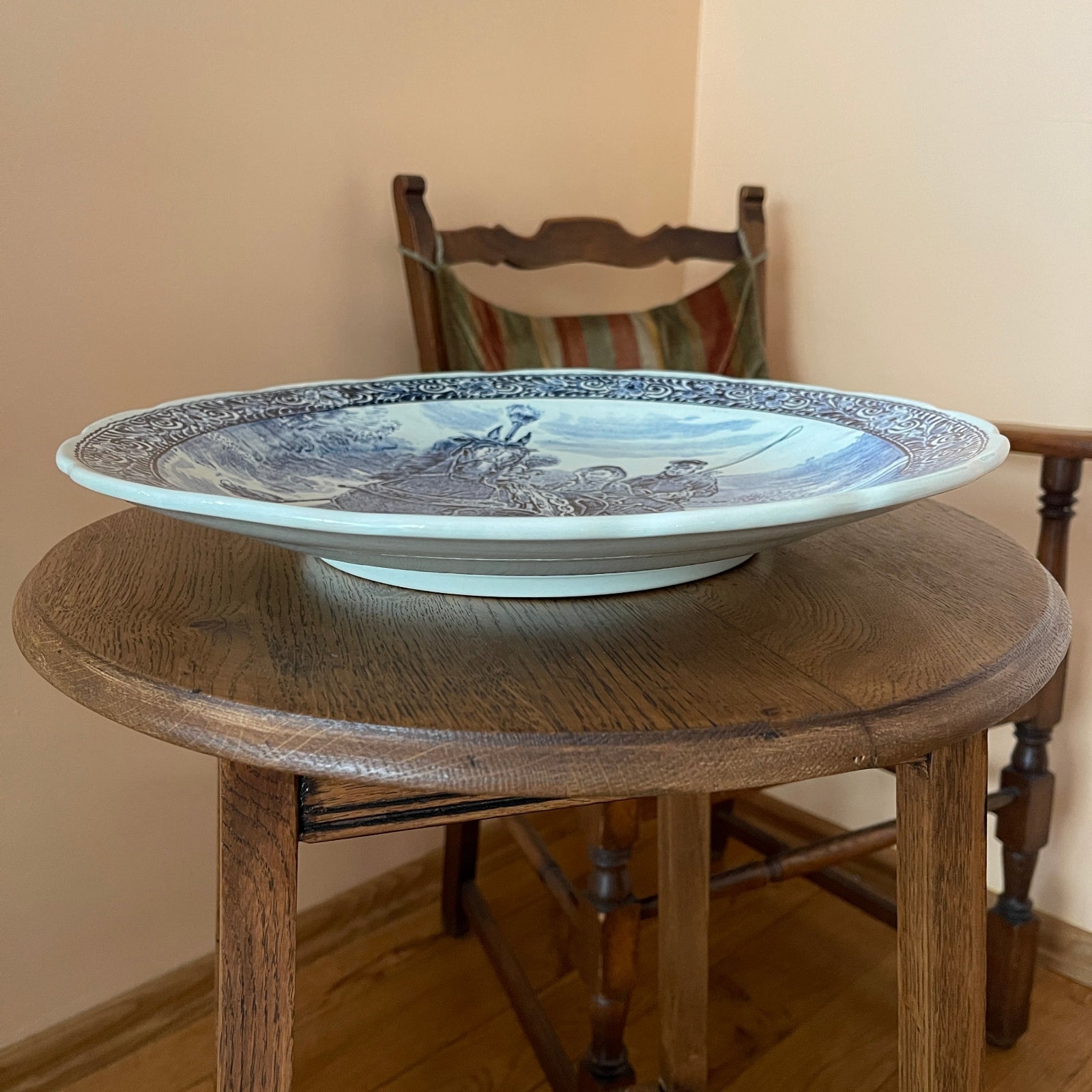 Decorative plate on a wooden table with a chair in the background