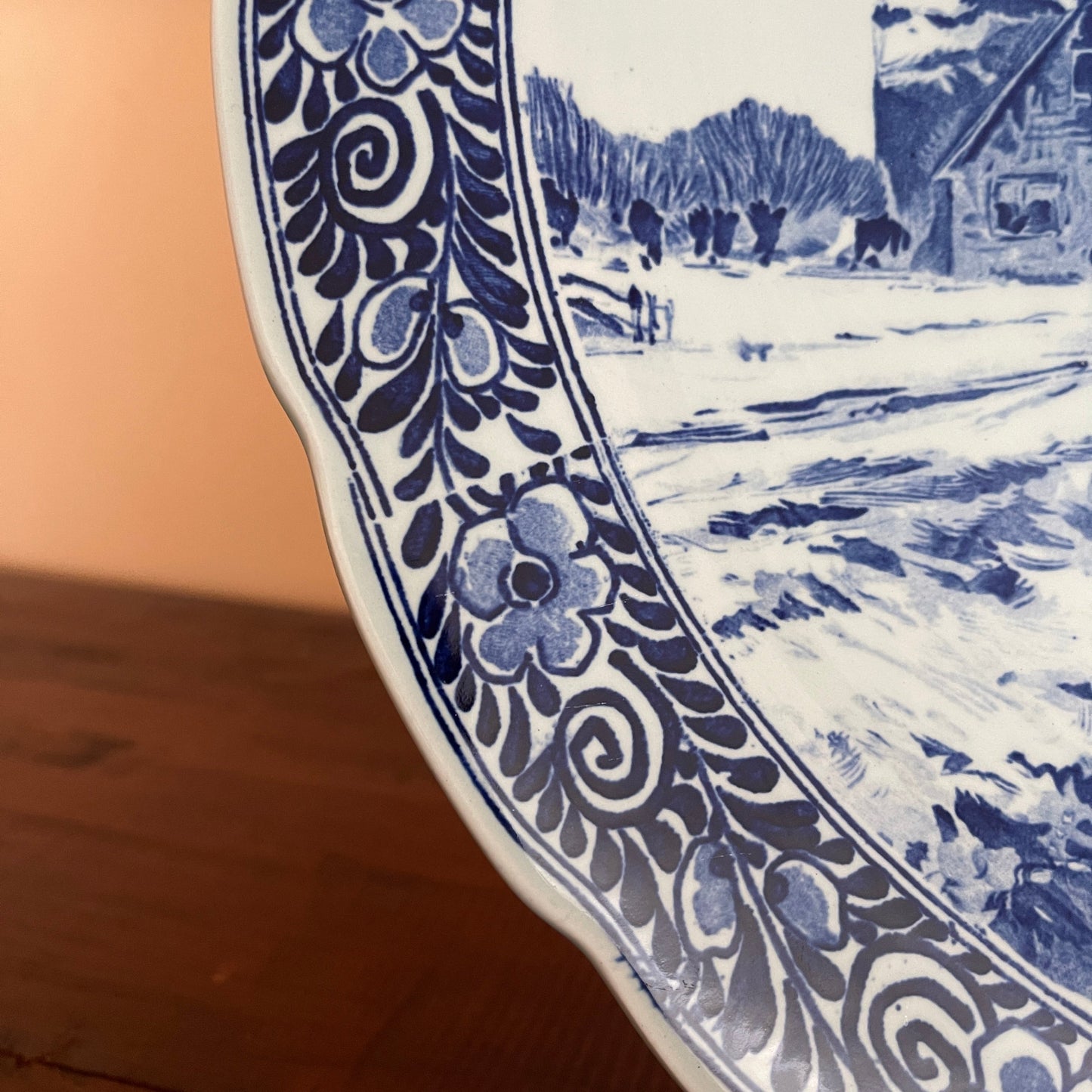 Close-up of a blue and white ceramic plate with decorative edge and landscape design.