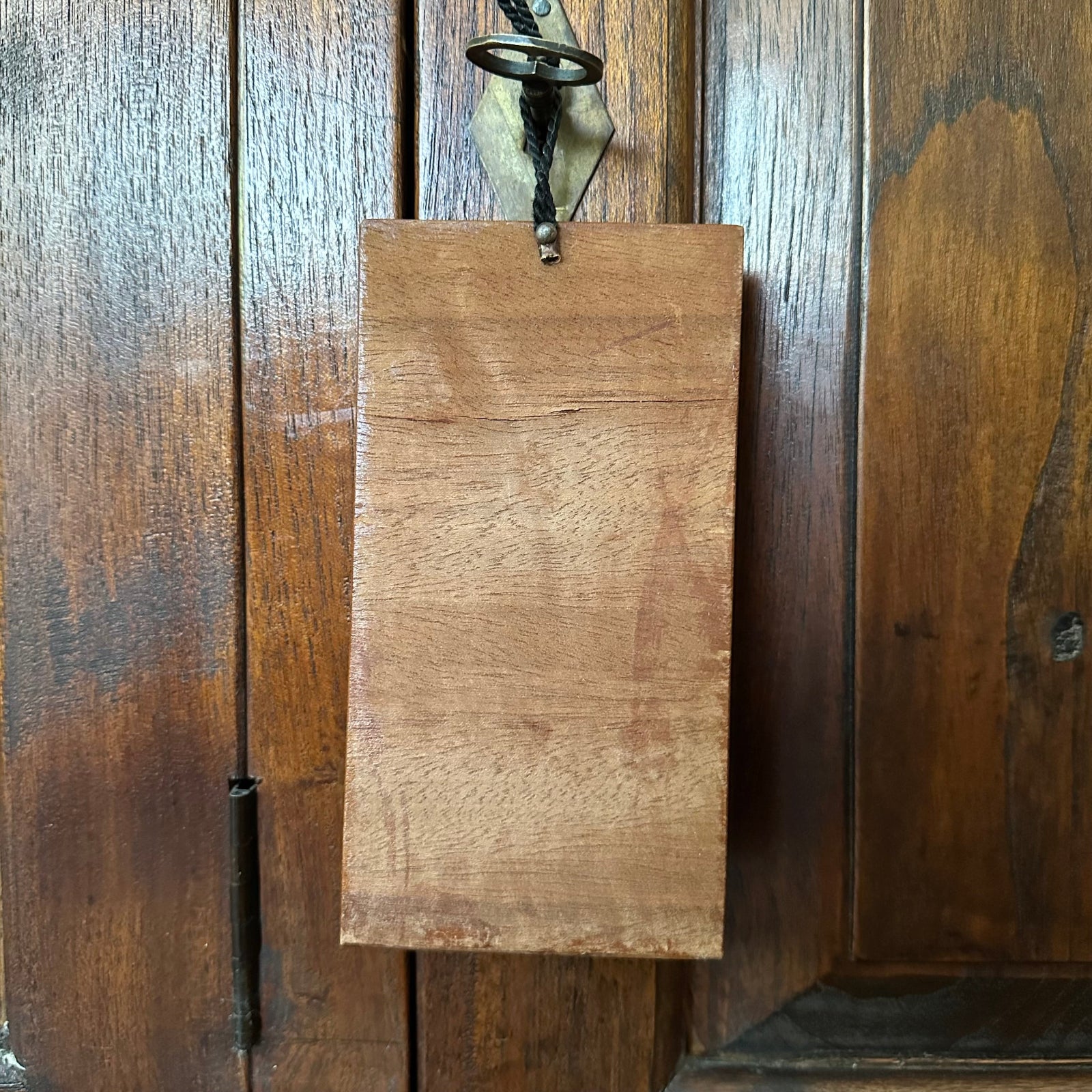 Wooden sign hanging on a wooden panel wall