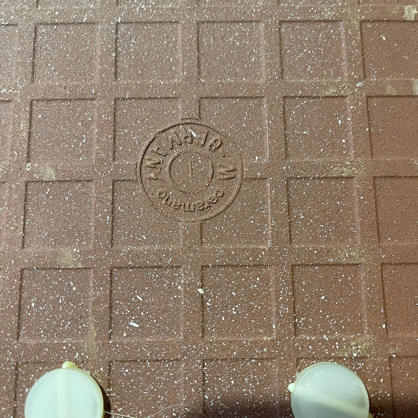 Brown paver with a circular stamp in the center, showing 'Paver & Stone Co.'