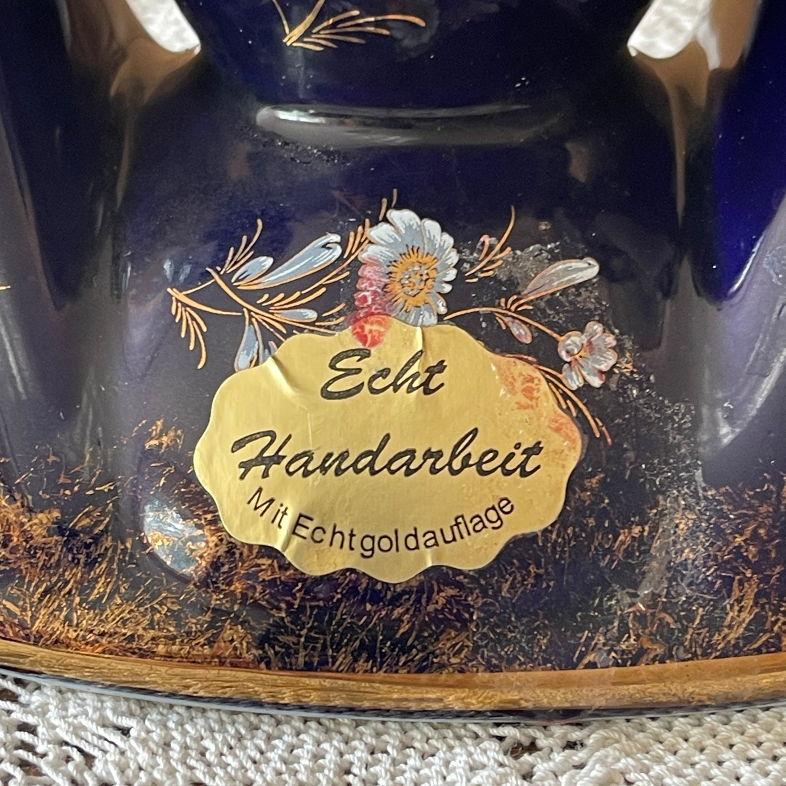 Decorative item with gold label and floral design on a dark background
