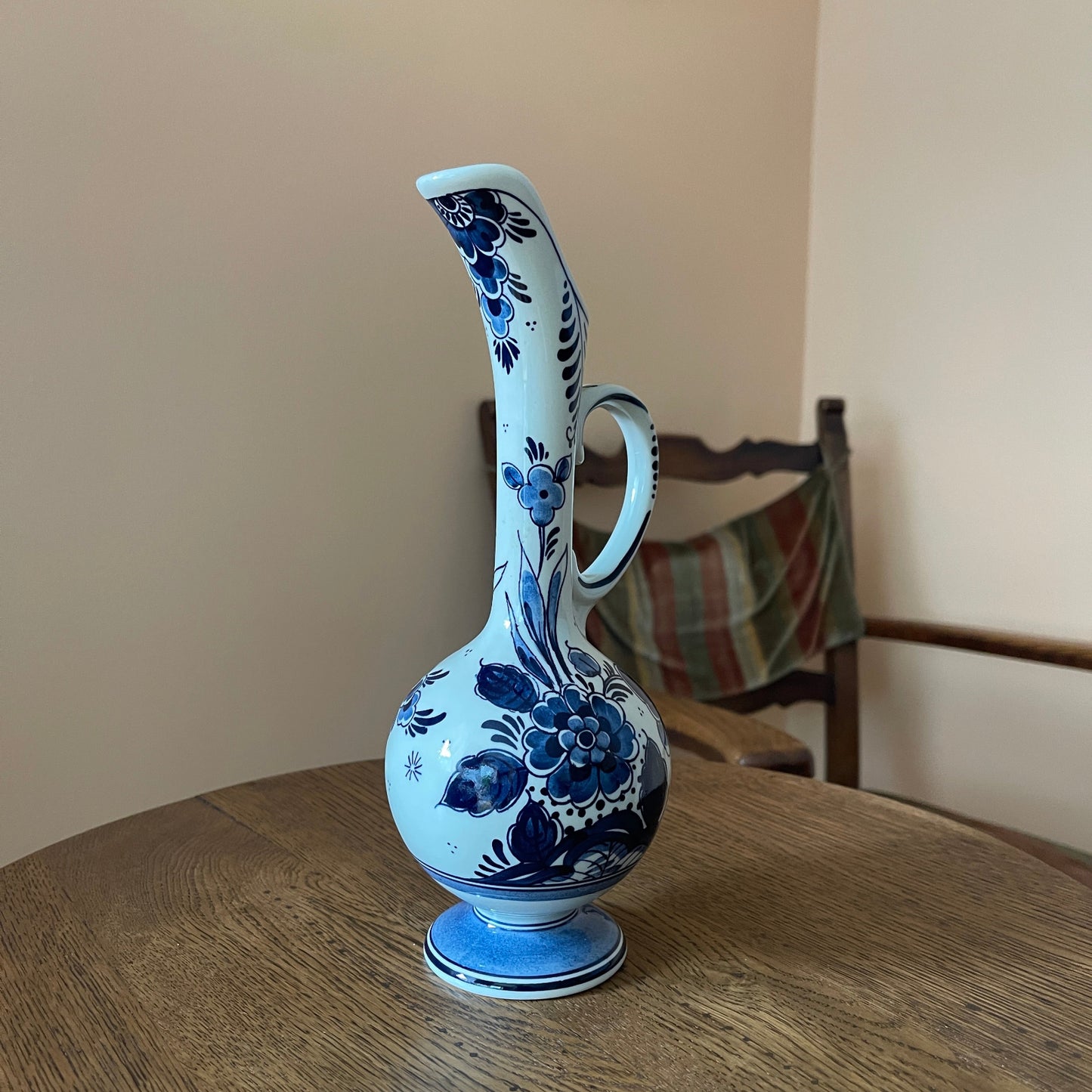 Blue and white ceramic vase on a wooden table with a neutral background