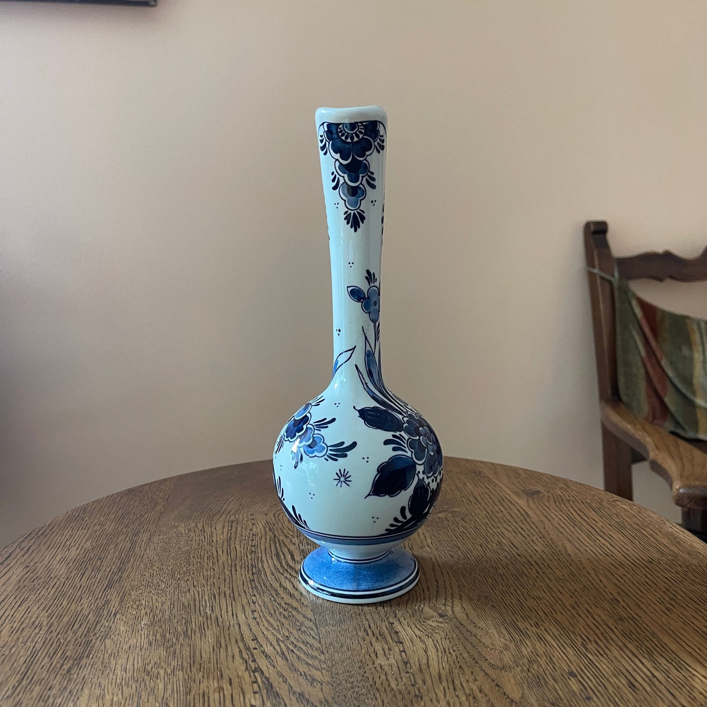 Blue and white ceramic vase on a wooden table with a neutral background