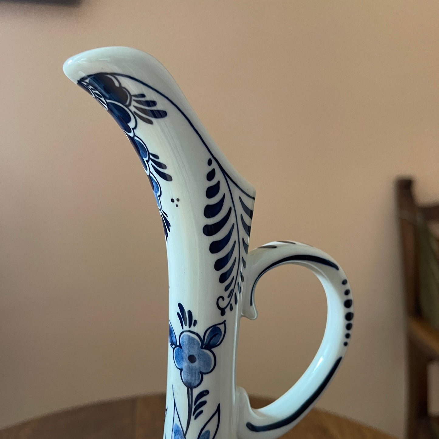 Ceramic pitcher with blue floral patterns on a neutral background