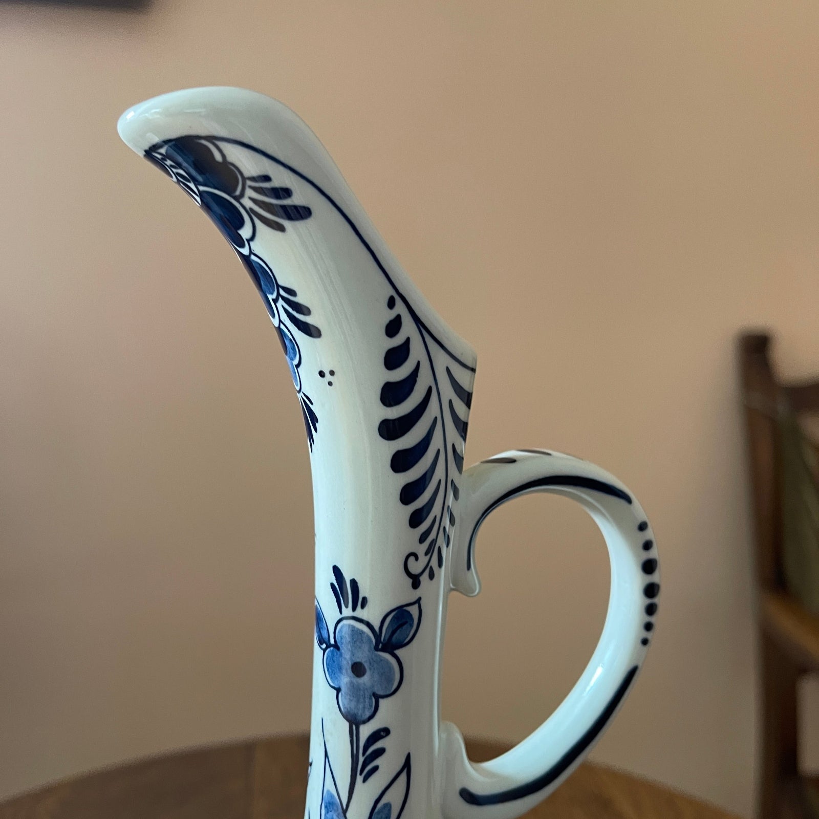 Ceramic pitcher with blue floral patterns on a neutral background