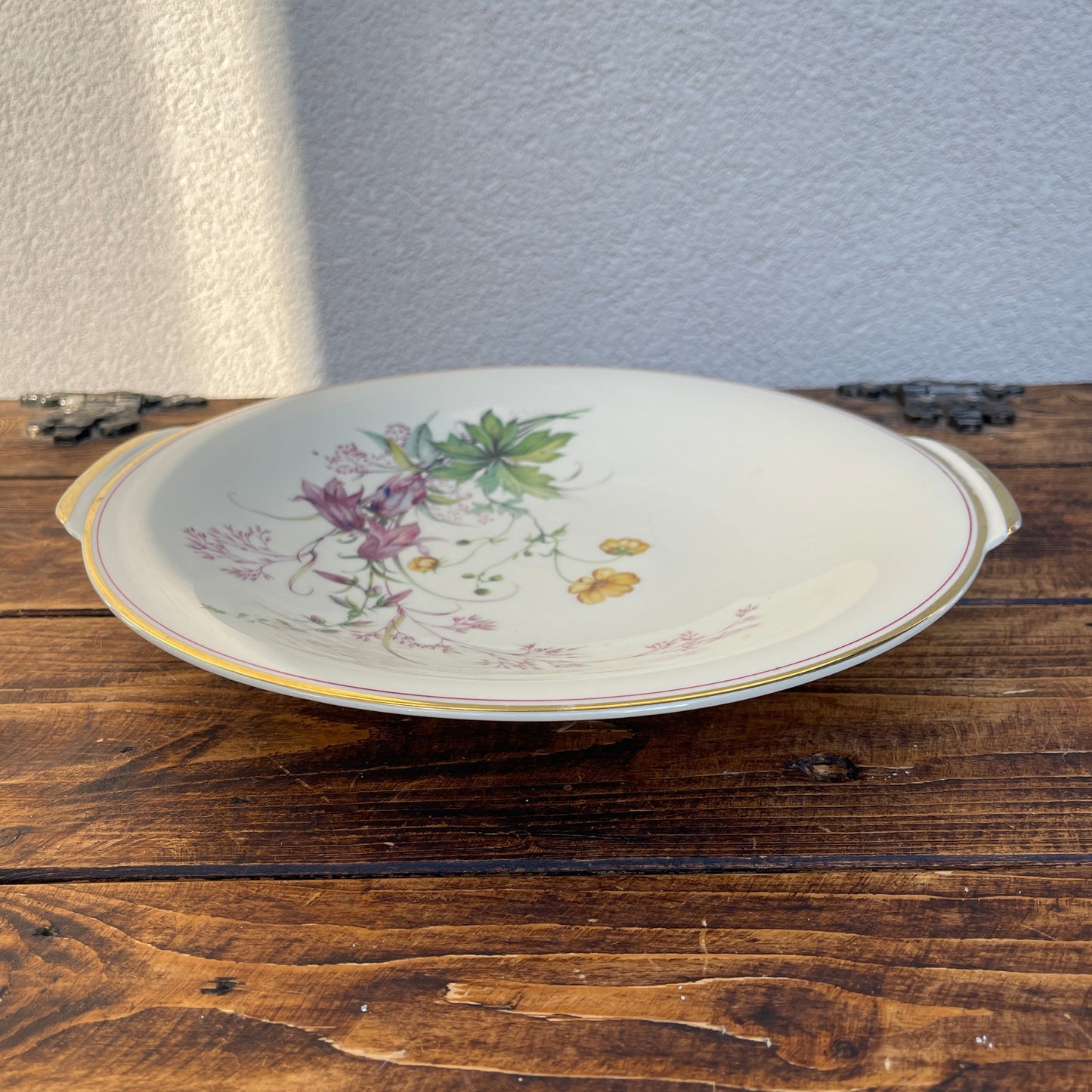 Decorative ceramic plate with floral design on a wooden surface