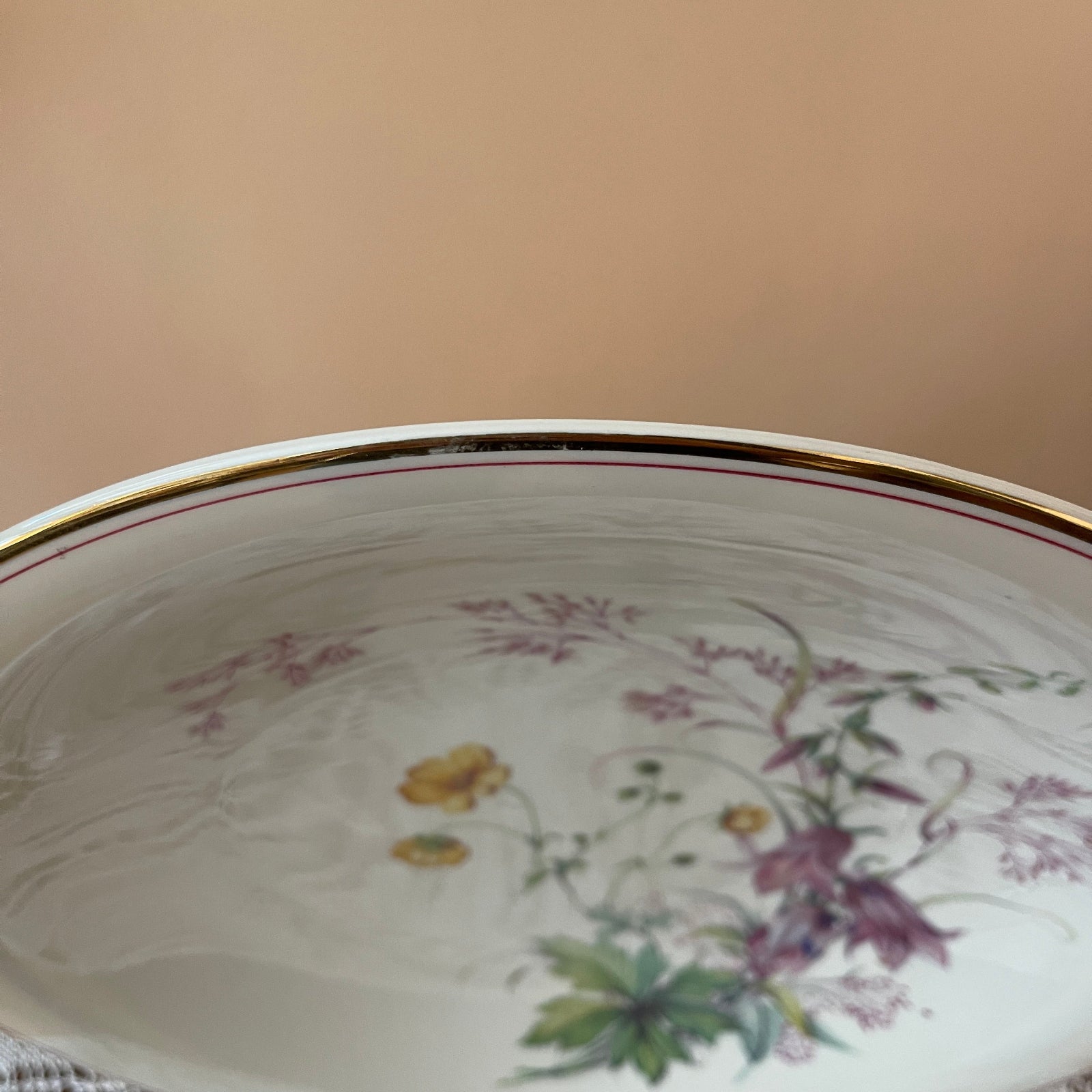 Decorative ceramic plate with floral patterns on a beige background