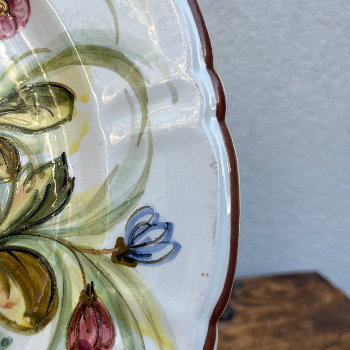 Close-up of a decorative ceramic plate with floral patterns on a plain background