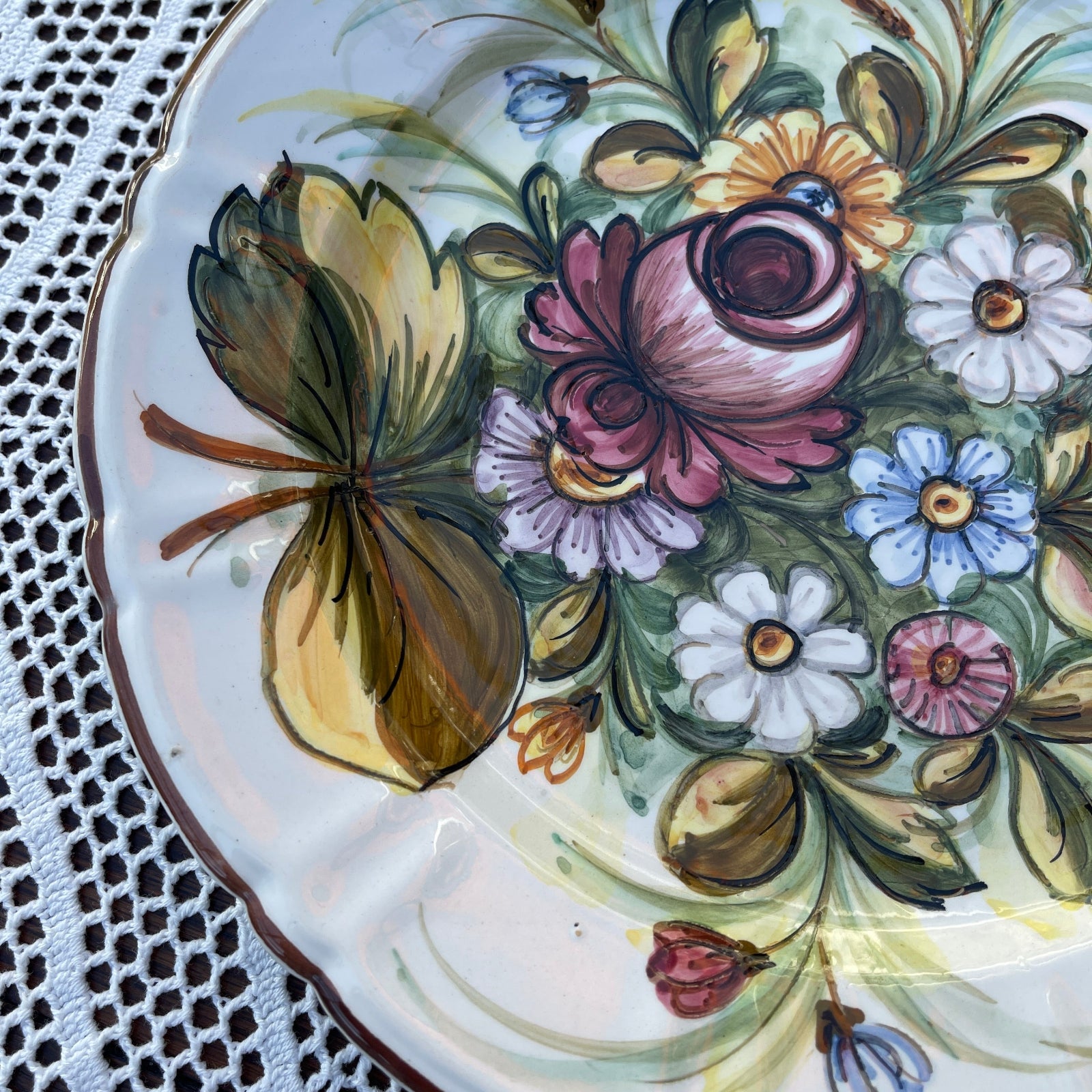 Decorative ceramic plate with floral patterns on a lace tablecloth