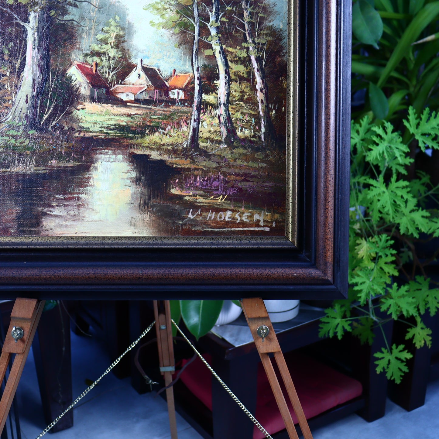 Oil painting of cottages behind trees