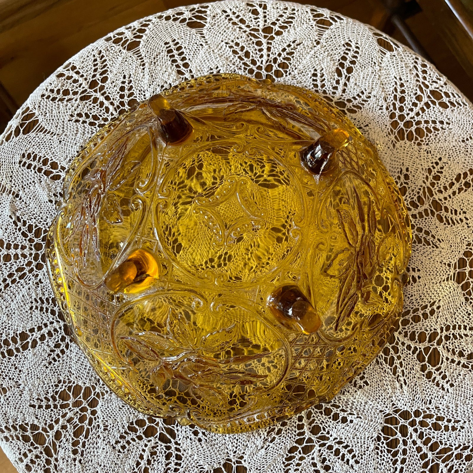 Decorative glass bowl with intricate designs on a lace tablecloth