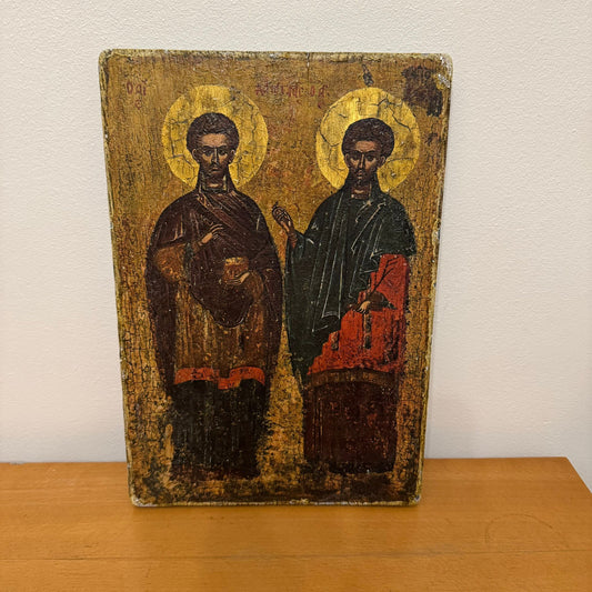 Vintage religious icon with two figures on a wooden surface