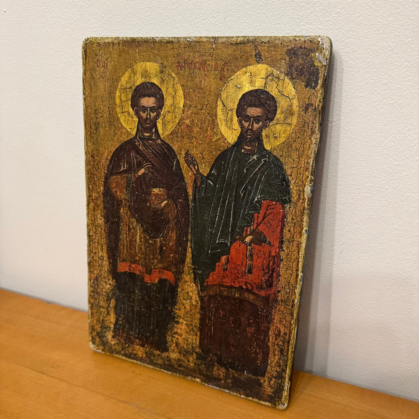 Vintage icon with two figures on a wooden surface