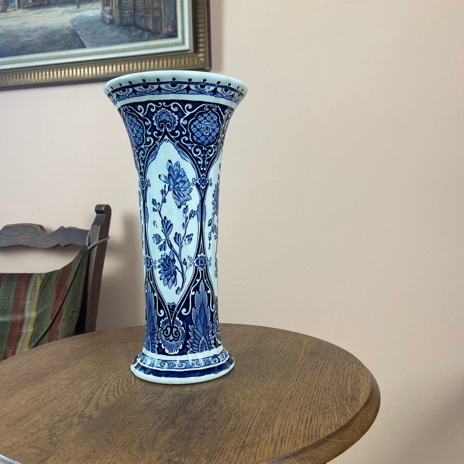 Blue and white decorative vase on a wooden table with a neutral background