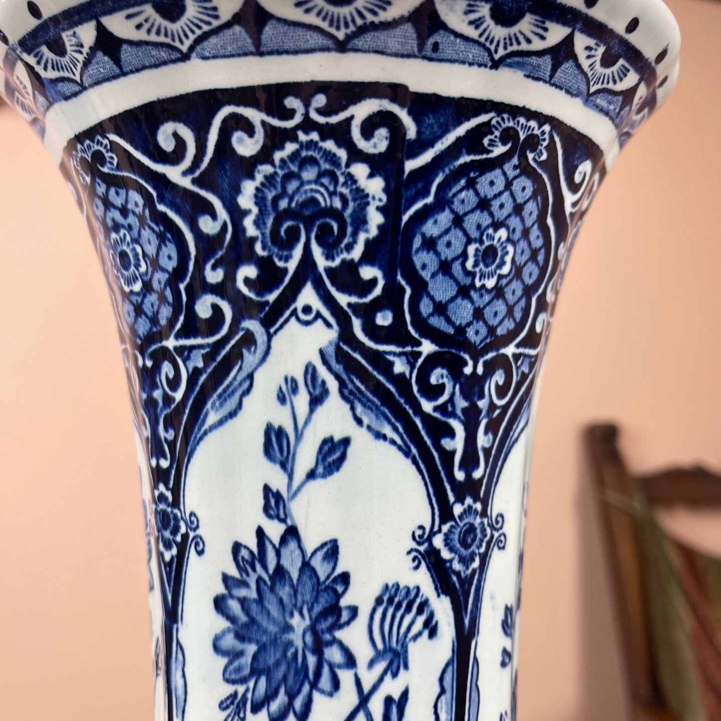 Ceramic vase with blue and white floral pattern on a beige background