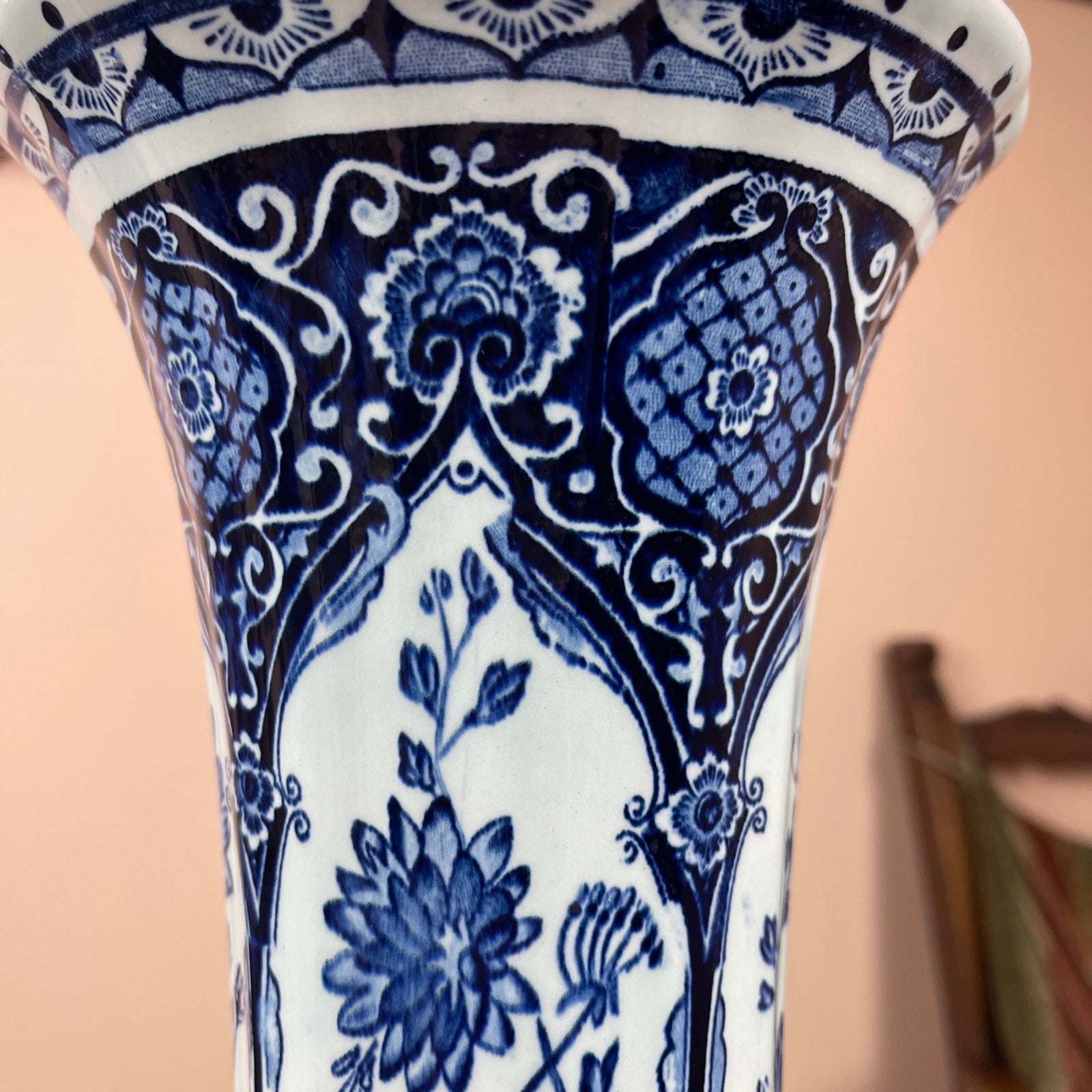 Ceramic vase with blue and white floral pattern on a beige background