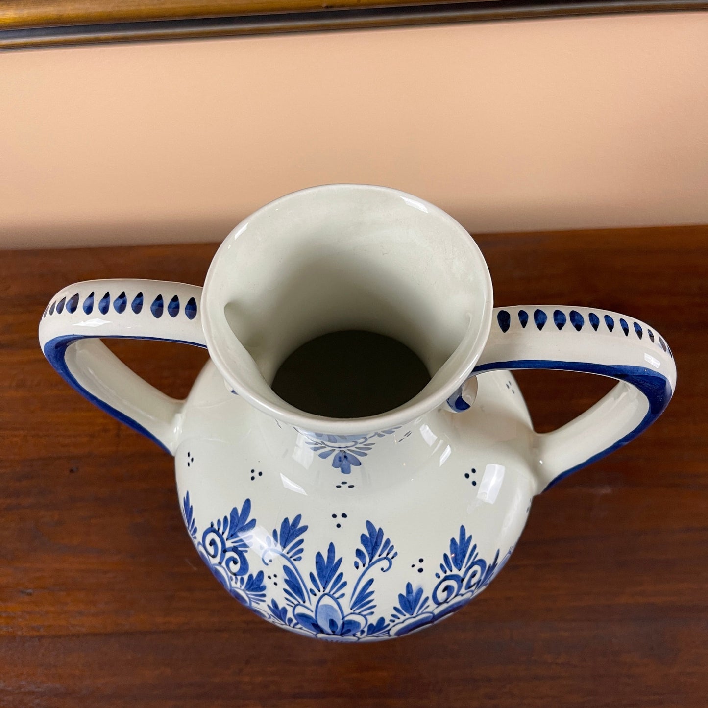 White ceramic pitcher with blue floral patterns on a wooden surface