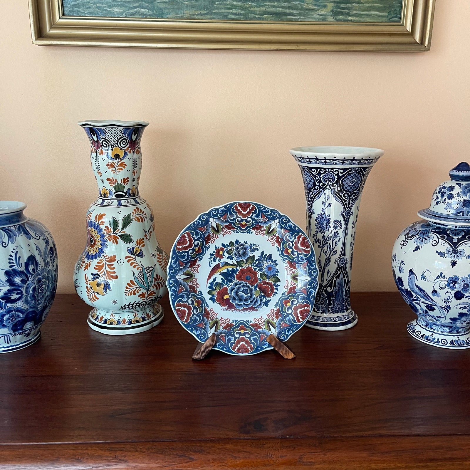 Collection of decorative ceramic vases and a plate with floral patterns on a wooden surface.