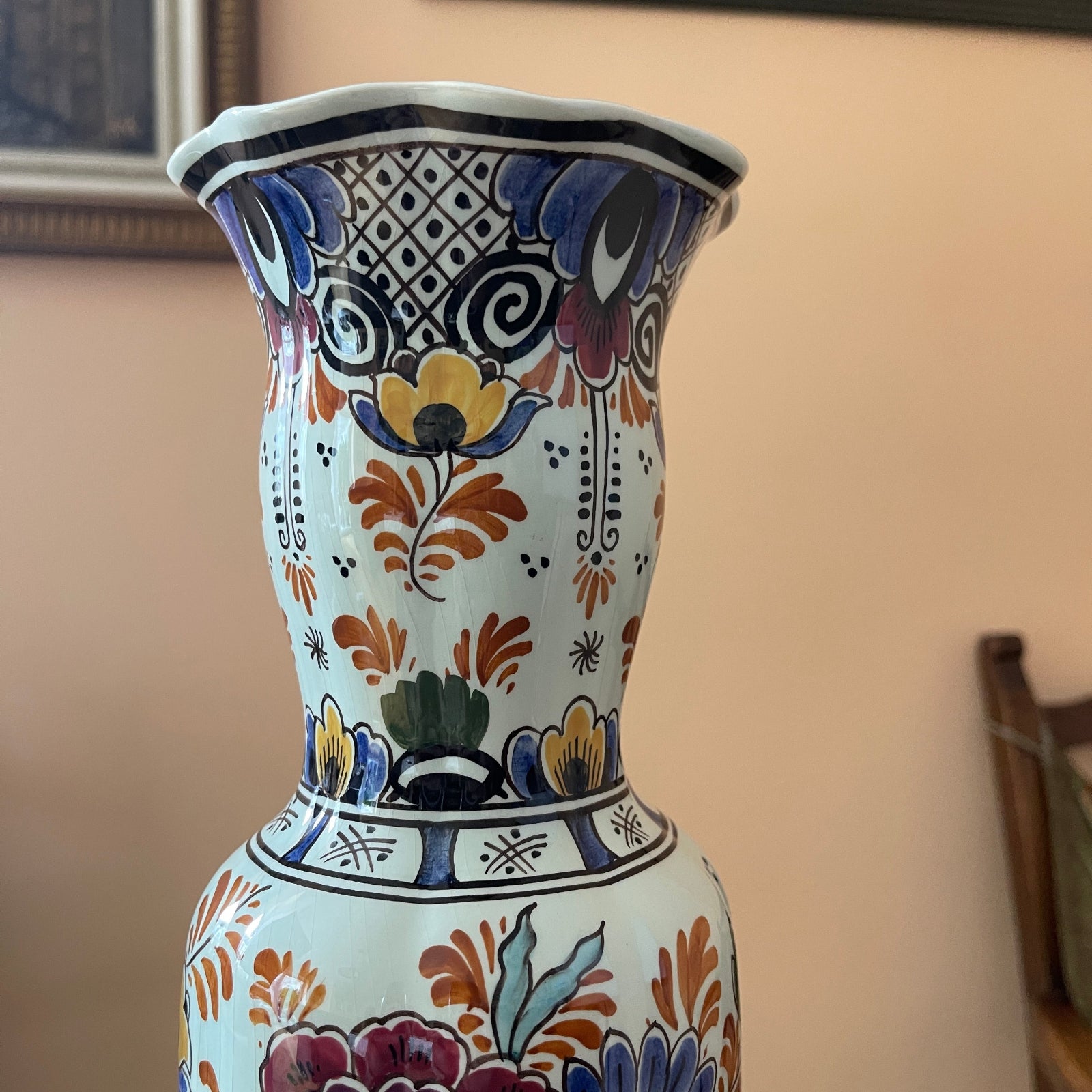 Decorative ceramic vase with colorful patterns on a neutral background