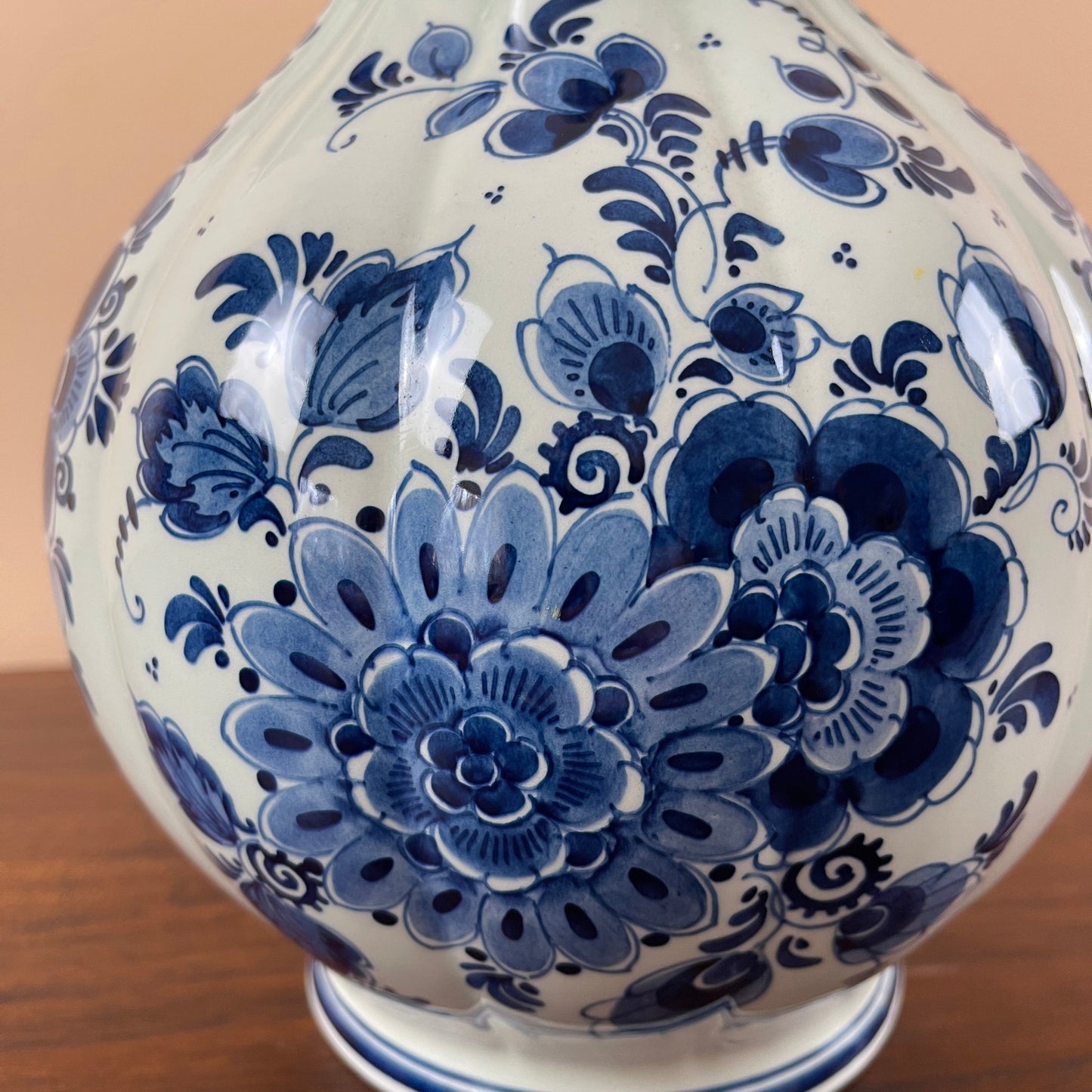 White ceramic vase with blue floral patterns on a wooden surface