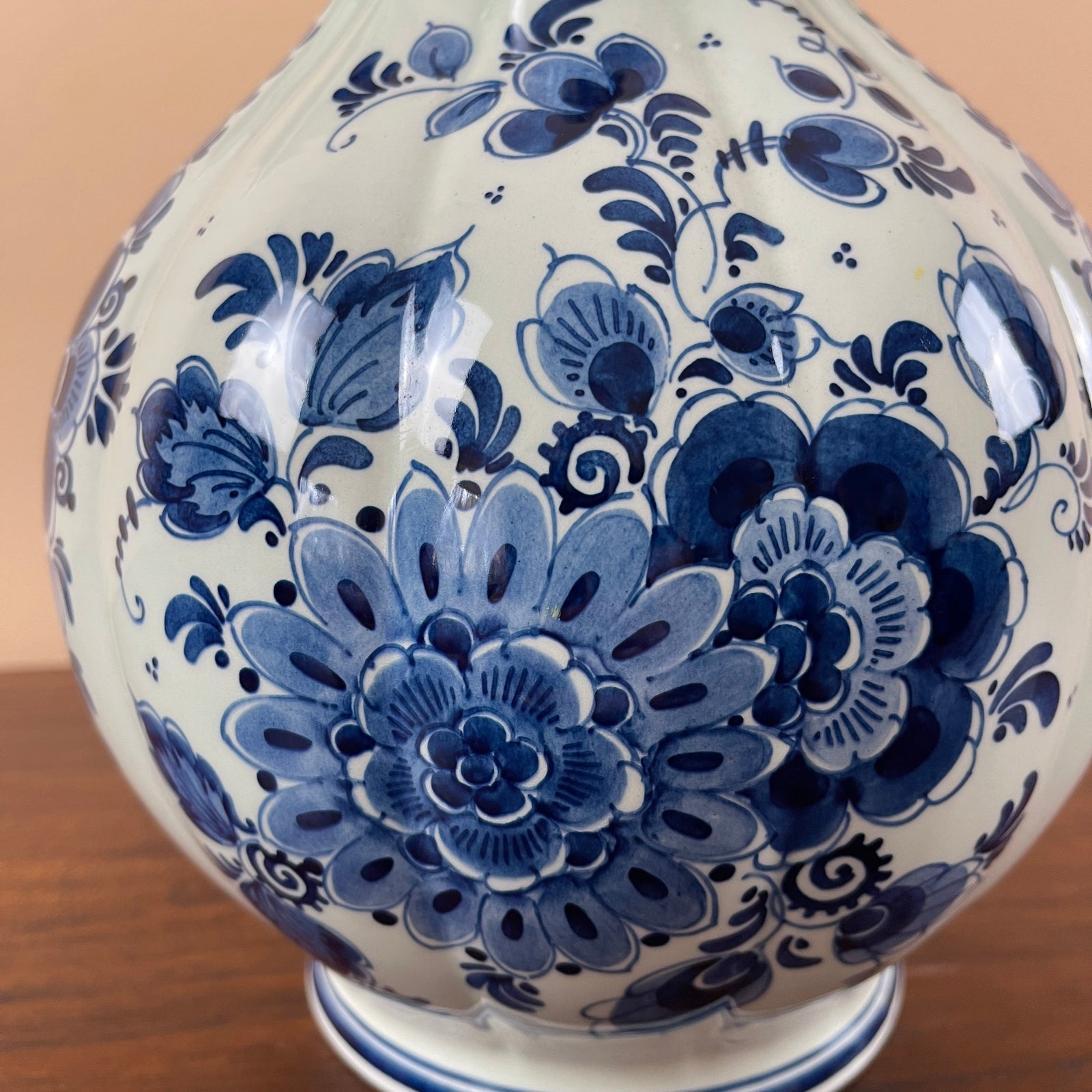 White ceramic vase with blue floral patterns on a wooden surface