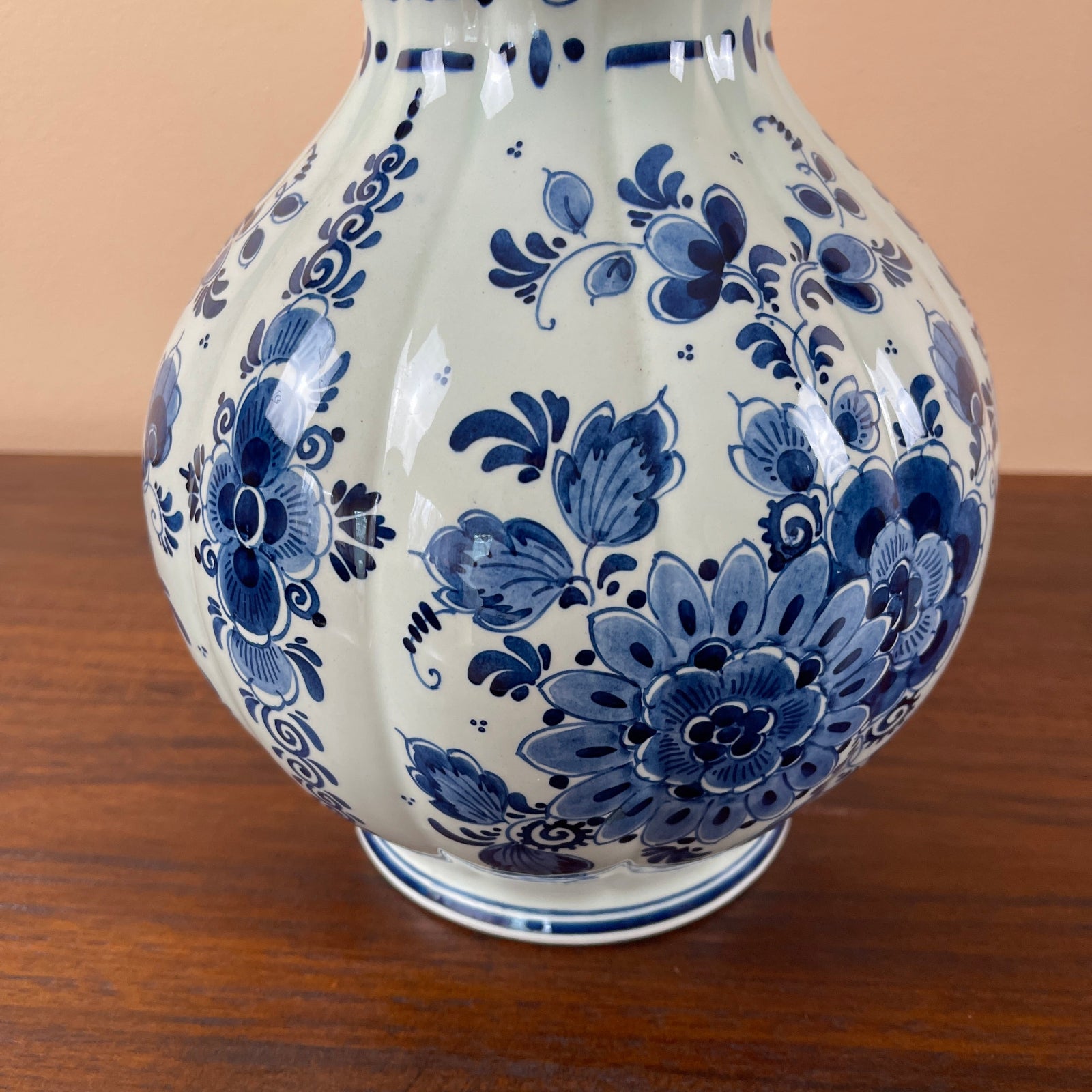 White ceramic vase with blue floral patterns on a wooden surface