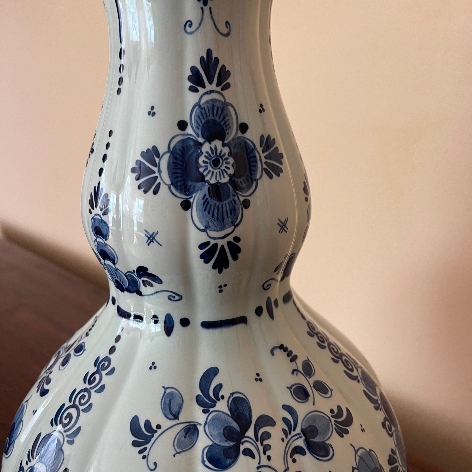 White vase with blue floral patterns on a beige background