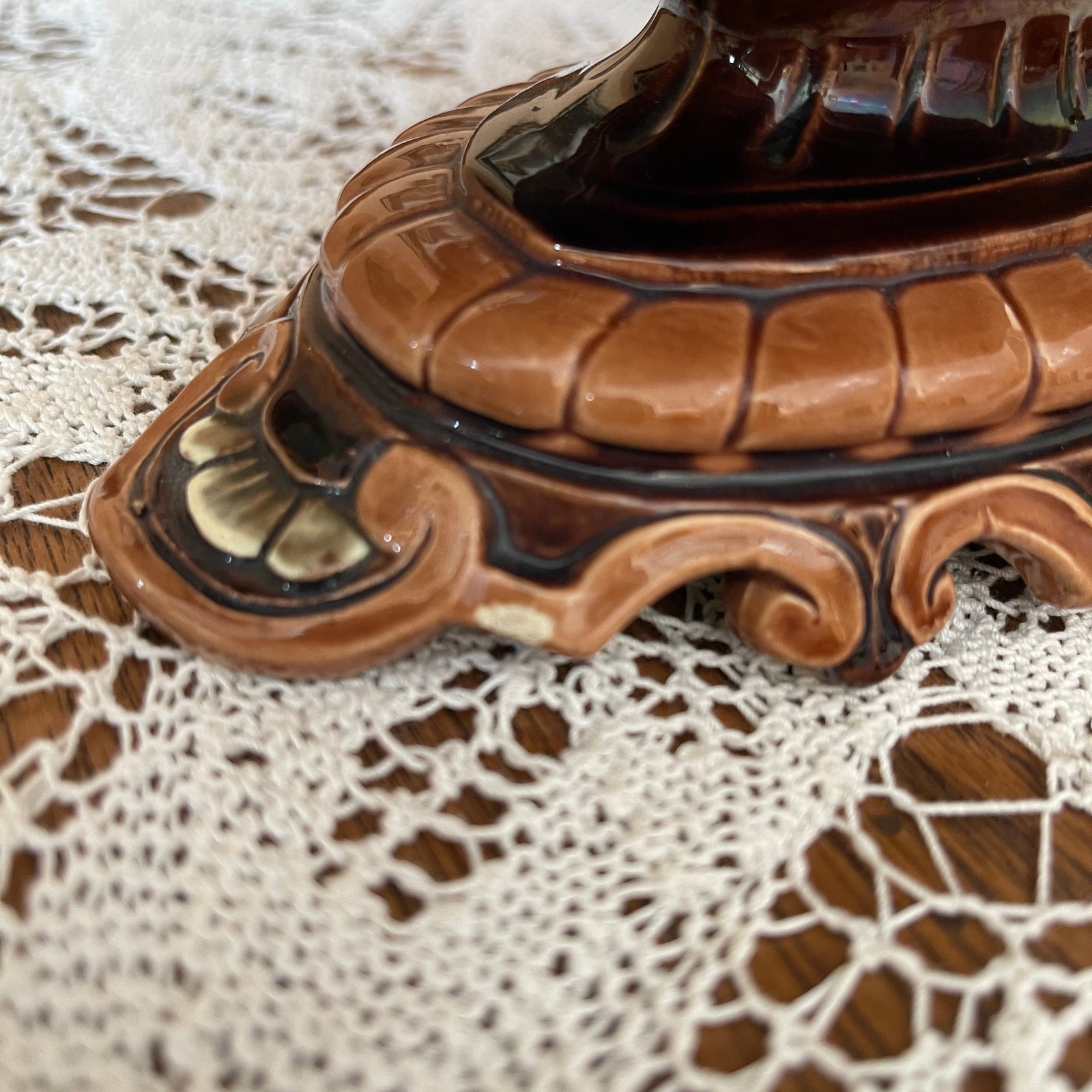 Decorative brown ceramic item on a lace tablecloth