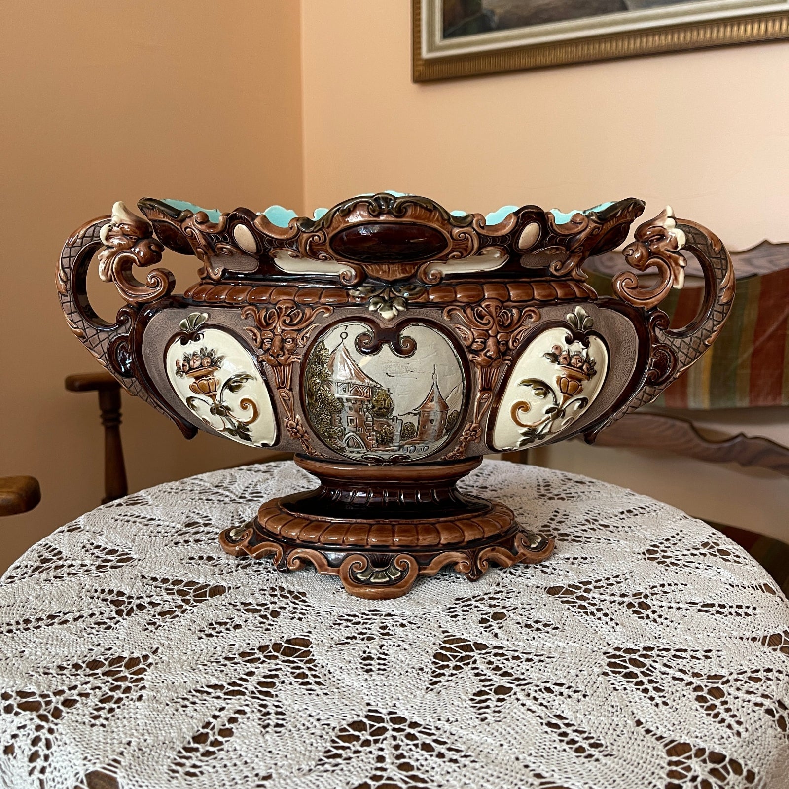 Decorative wooden bowl with intricate carvings on a lace tablecloth