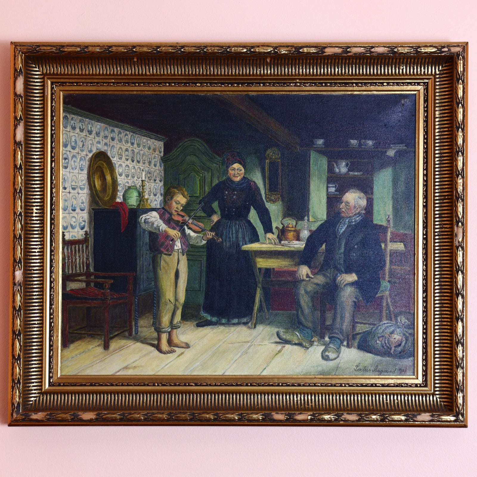 An oil painting depicting a boy playing the violin in front of two elderly people, housed in a gold-painted frame, with visible signs of wear.