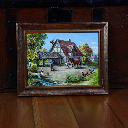 An oil painting of a farm scene with a house, a horse, and people, framed and set against a wooden background.