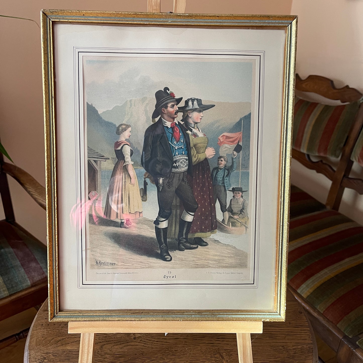 Framed print of a historical scene with people on an easel