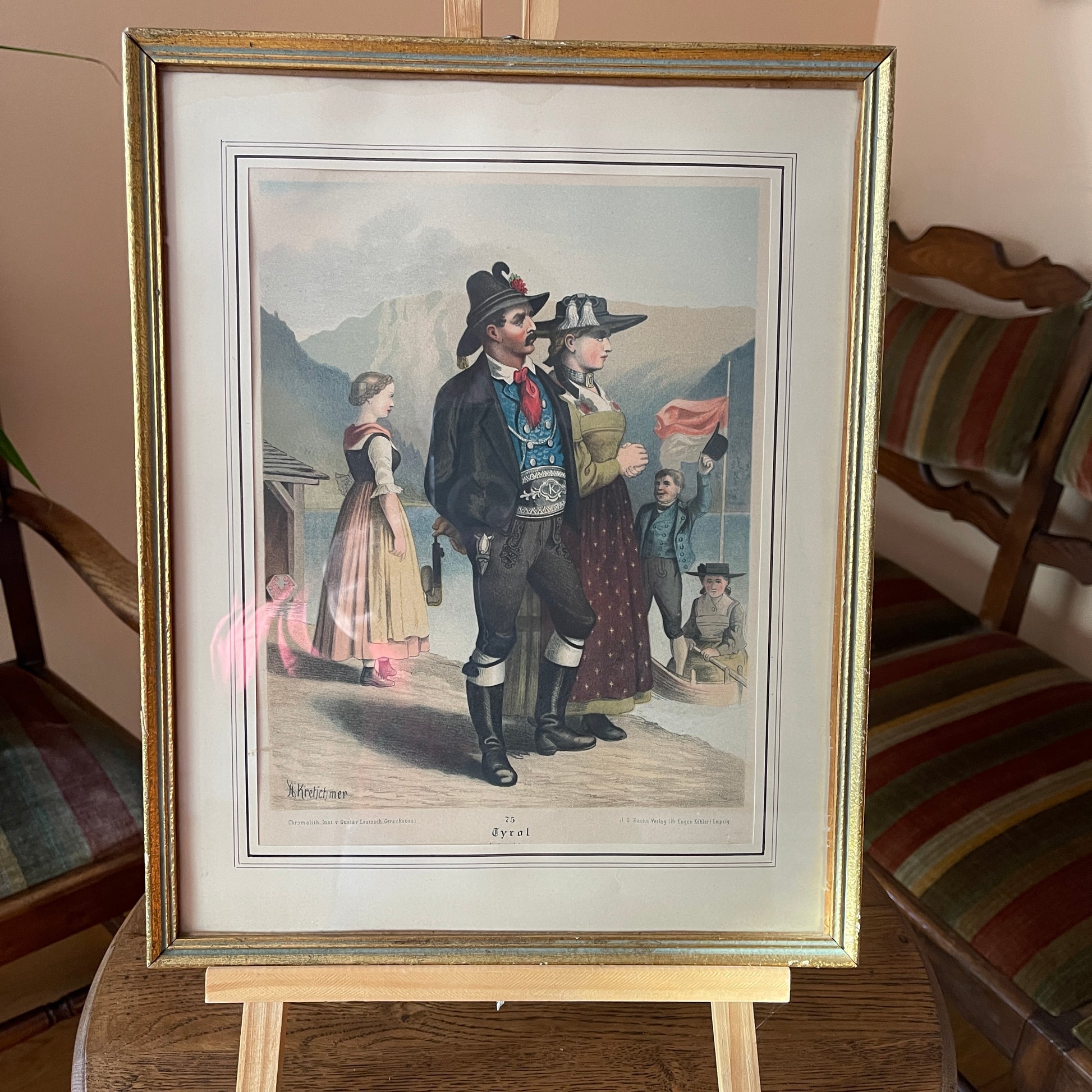 Framed print of a historical scene with people on an easel