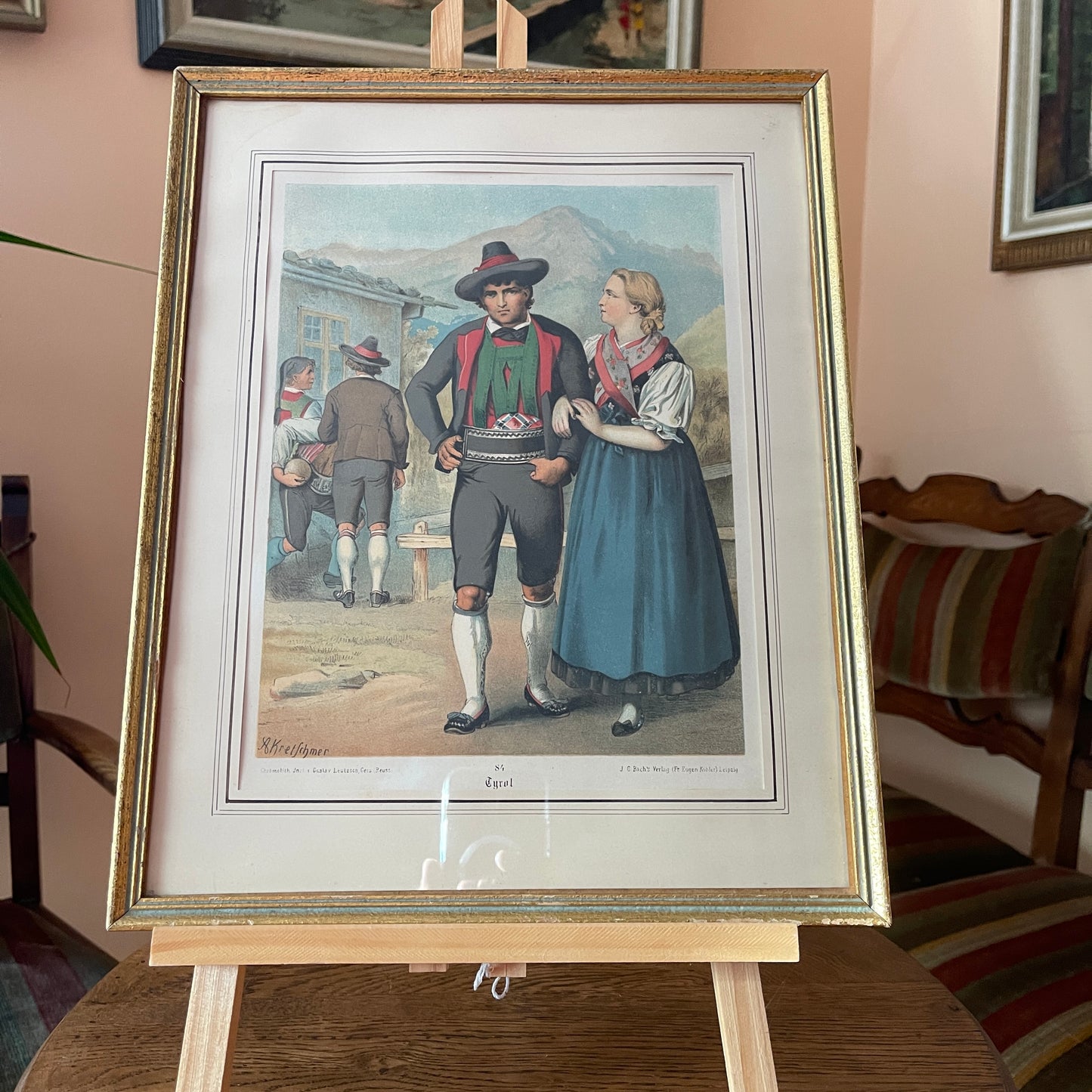 Framed artwork of a couple in traditional attire on an easel.