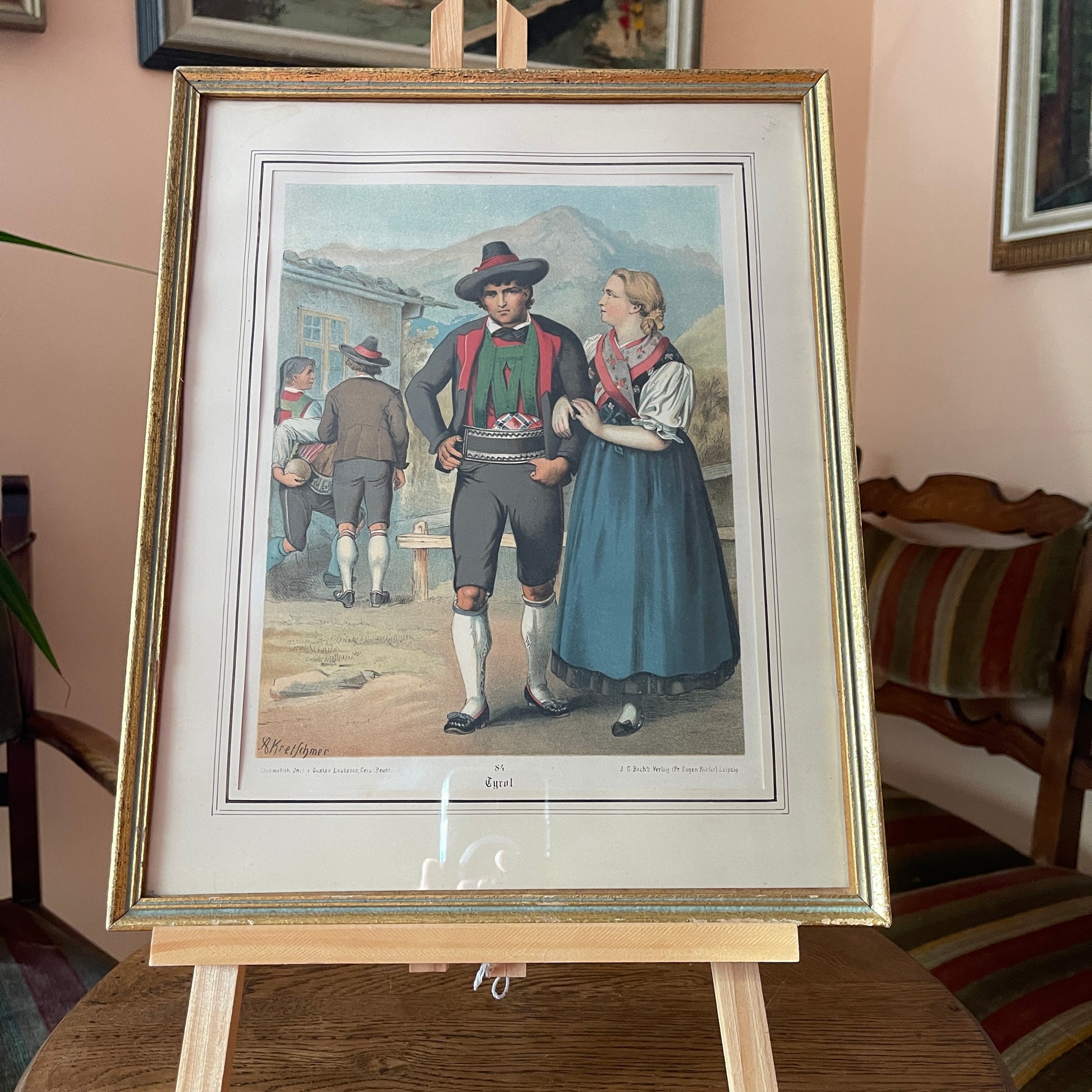 Framed artwork of a couple in traditional attire on an easel.