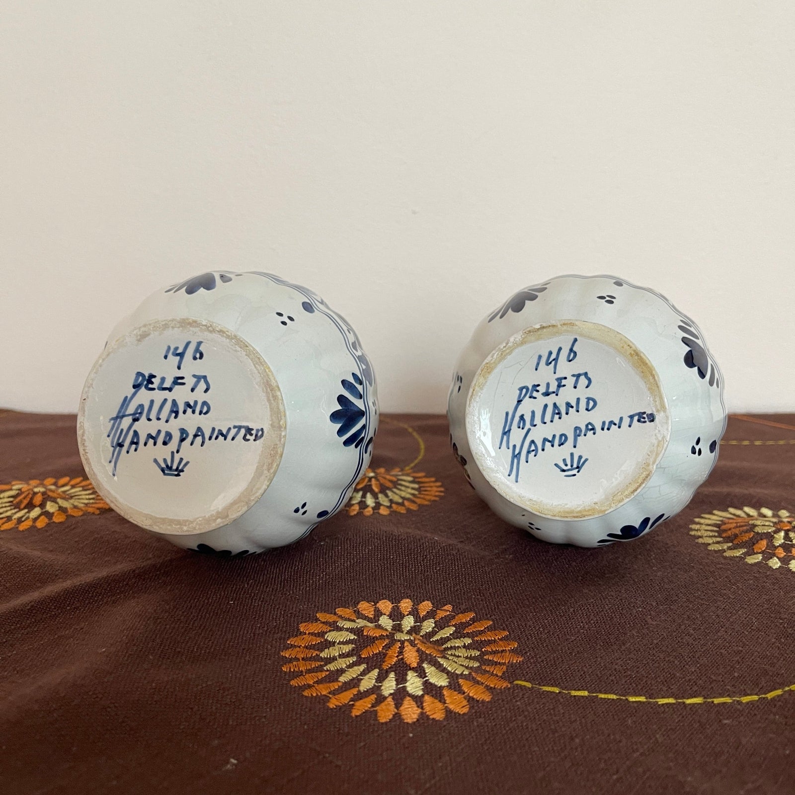 Two ceramic knobs with blue floral patterns on a brown fabric background