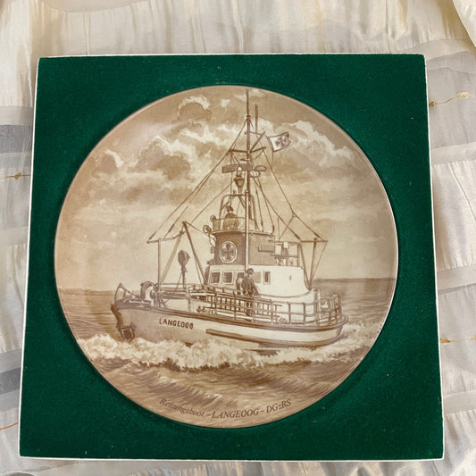 Decorative plate with a ship design on a green border