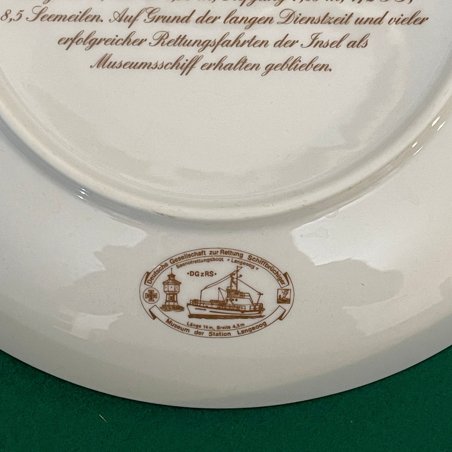 White plate with brown text and logo on a green background