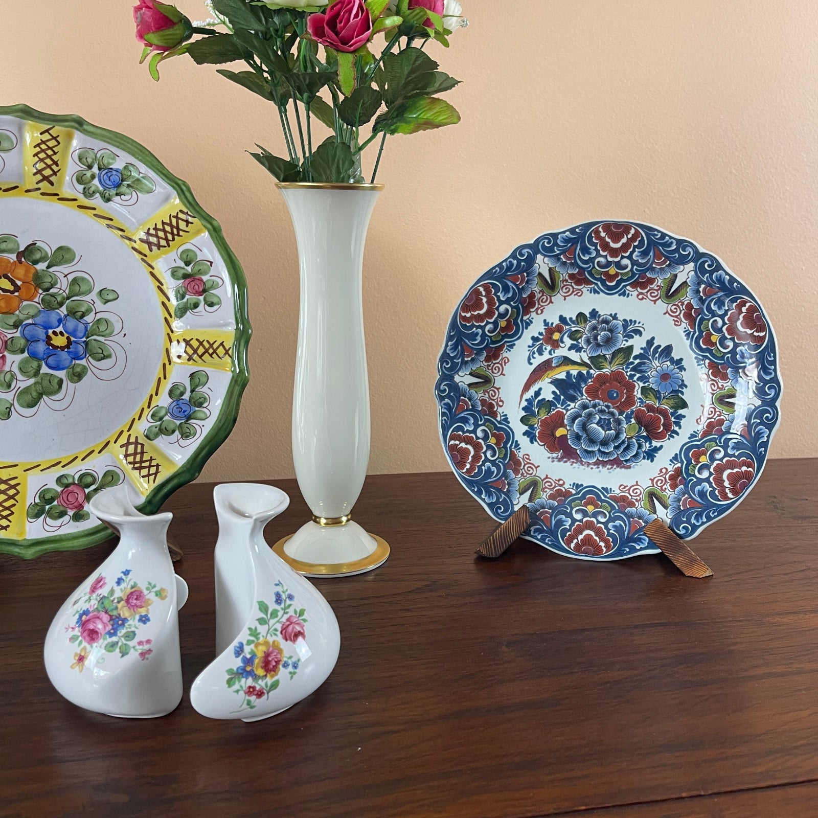Decorative ceramic plates and vases on a wooden surface with a beige background