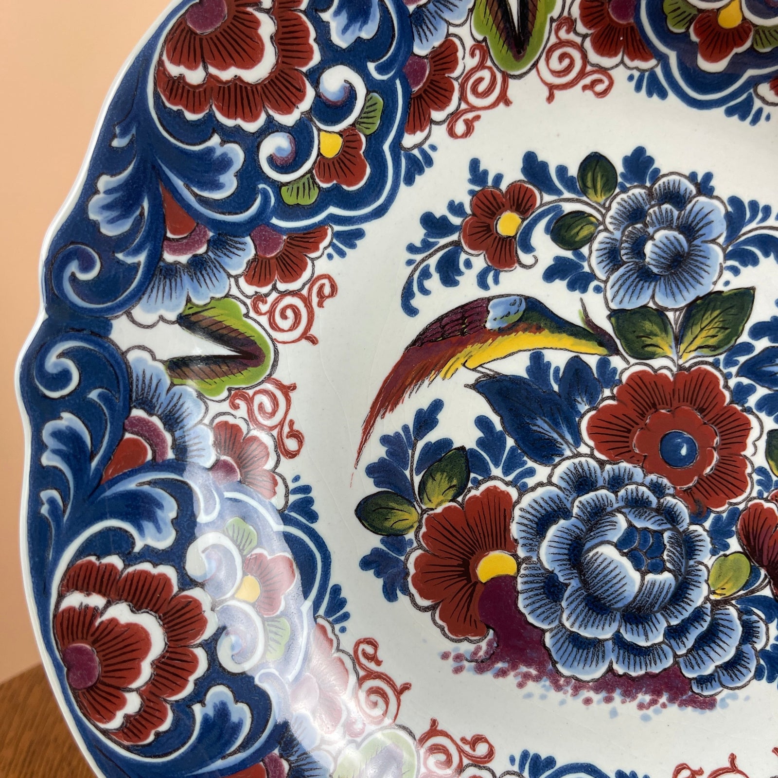 Decorative ceramic plate with floral and bird patterns on a beige background