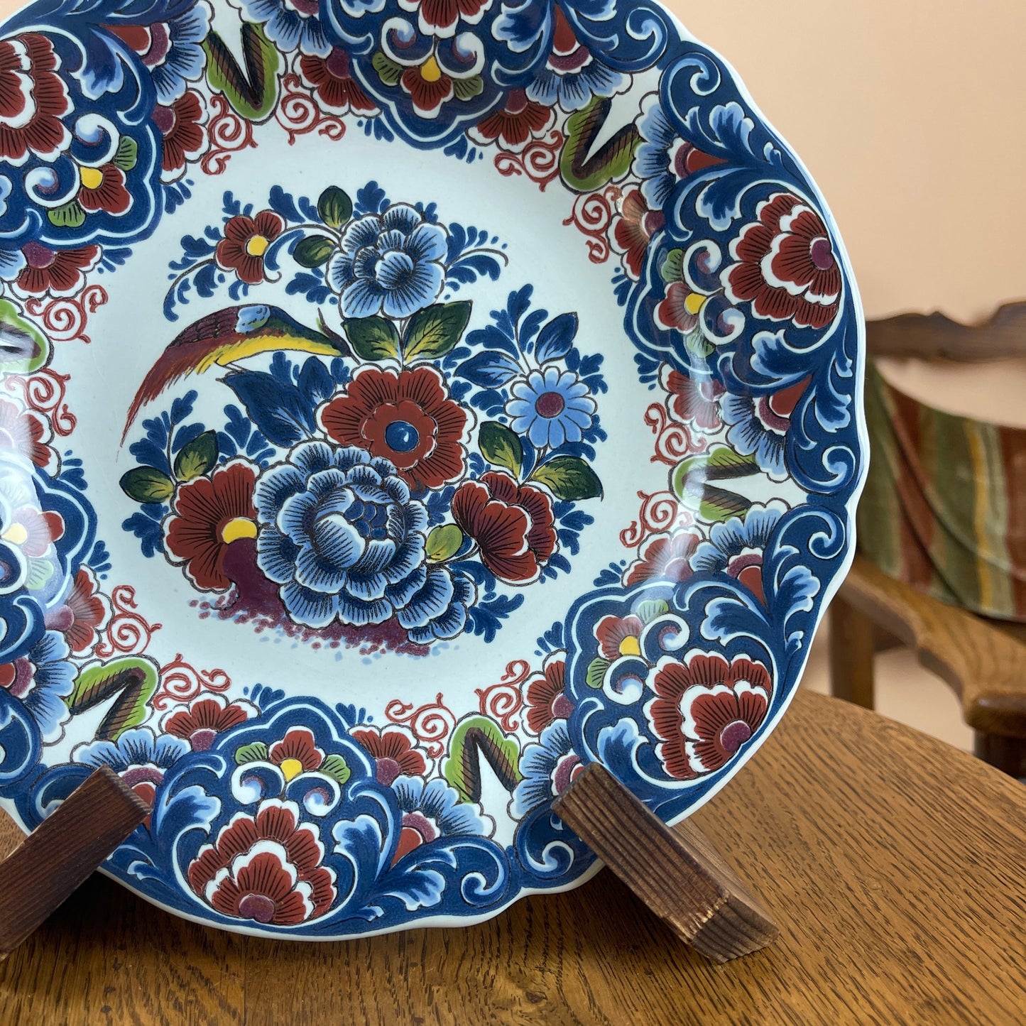 Decorative plate with floral and bird design on a wooden stand