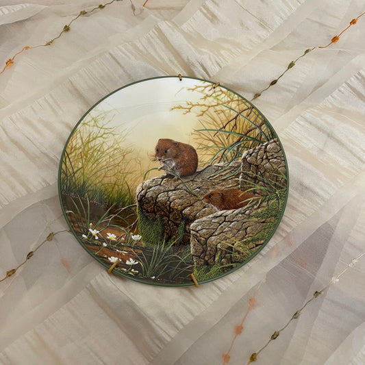 Decorative plate with nature-themed design featuring animals on a textured surface.
