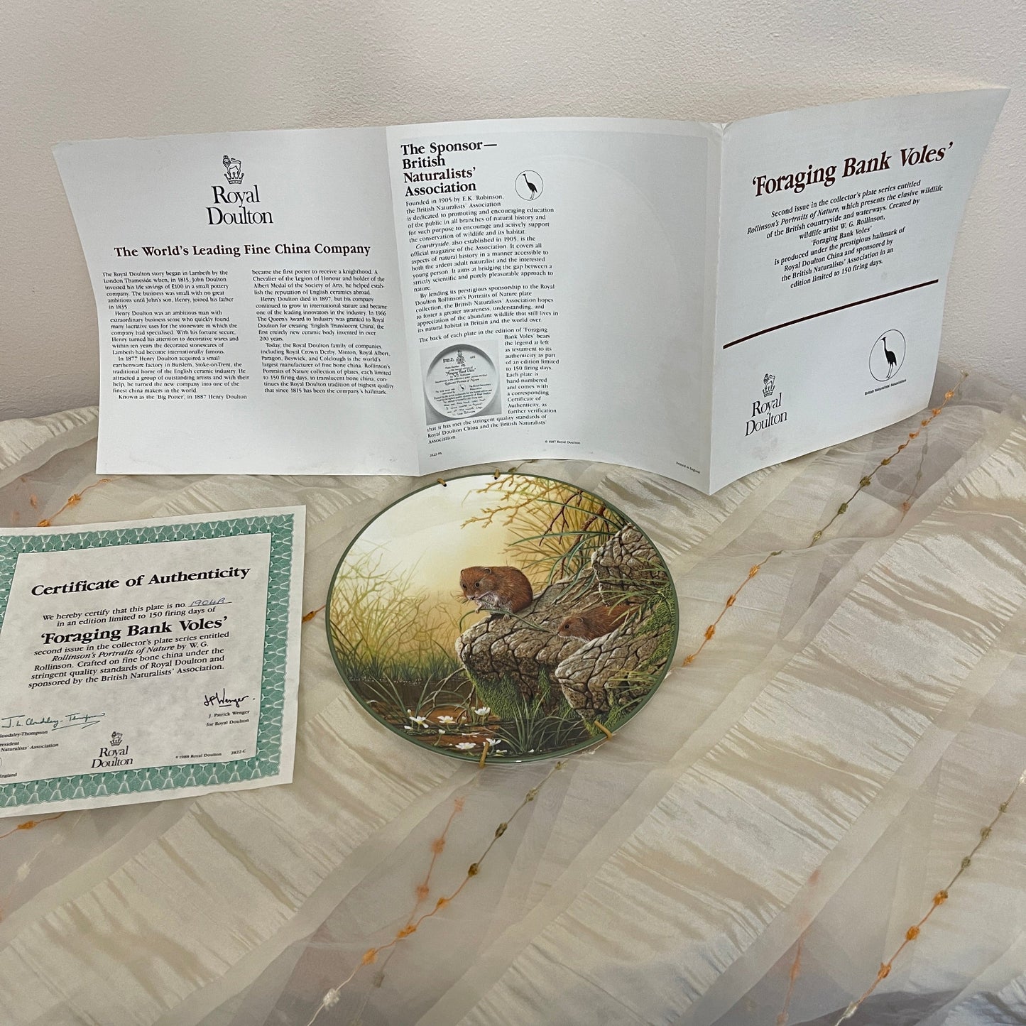 Royal Doulton plate with certificate of authenticity and information sheet on a textured surface
