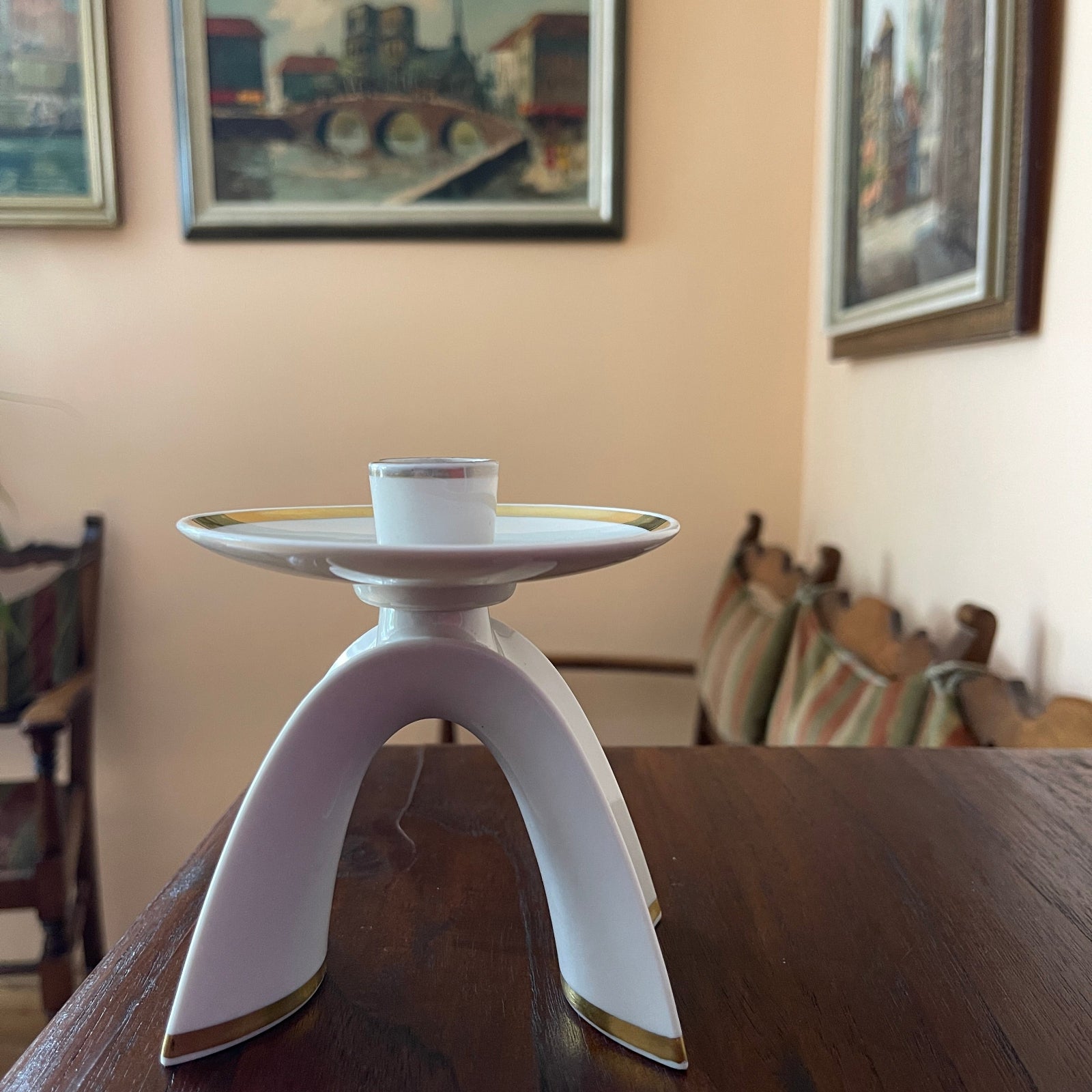 White candle holder on a wooden table with a blurred background