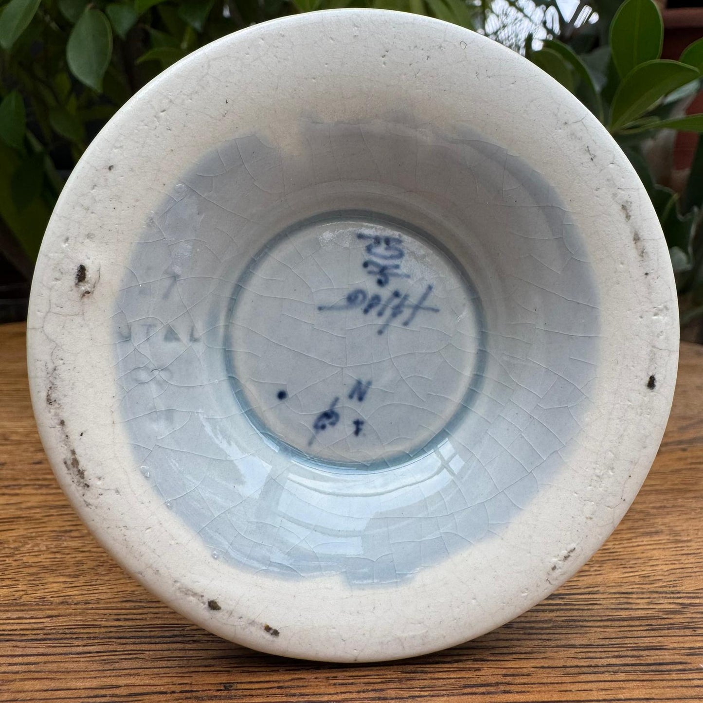 White ceramic bowl with blue text on a wooden surface