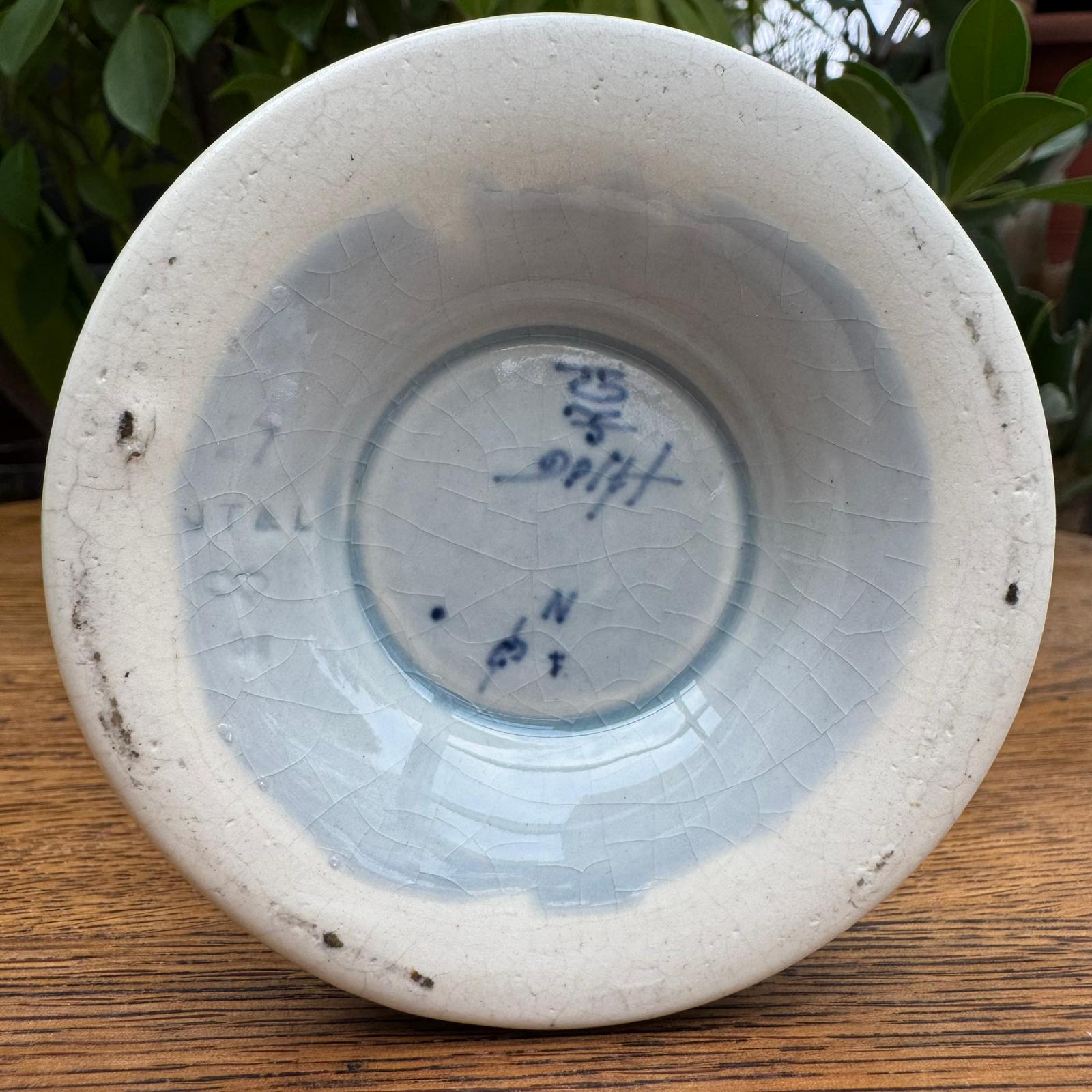 White ceramic bowl with blue text on a wooden surface