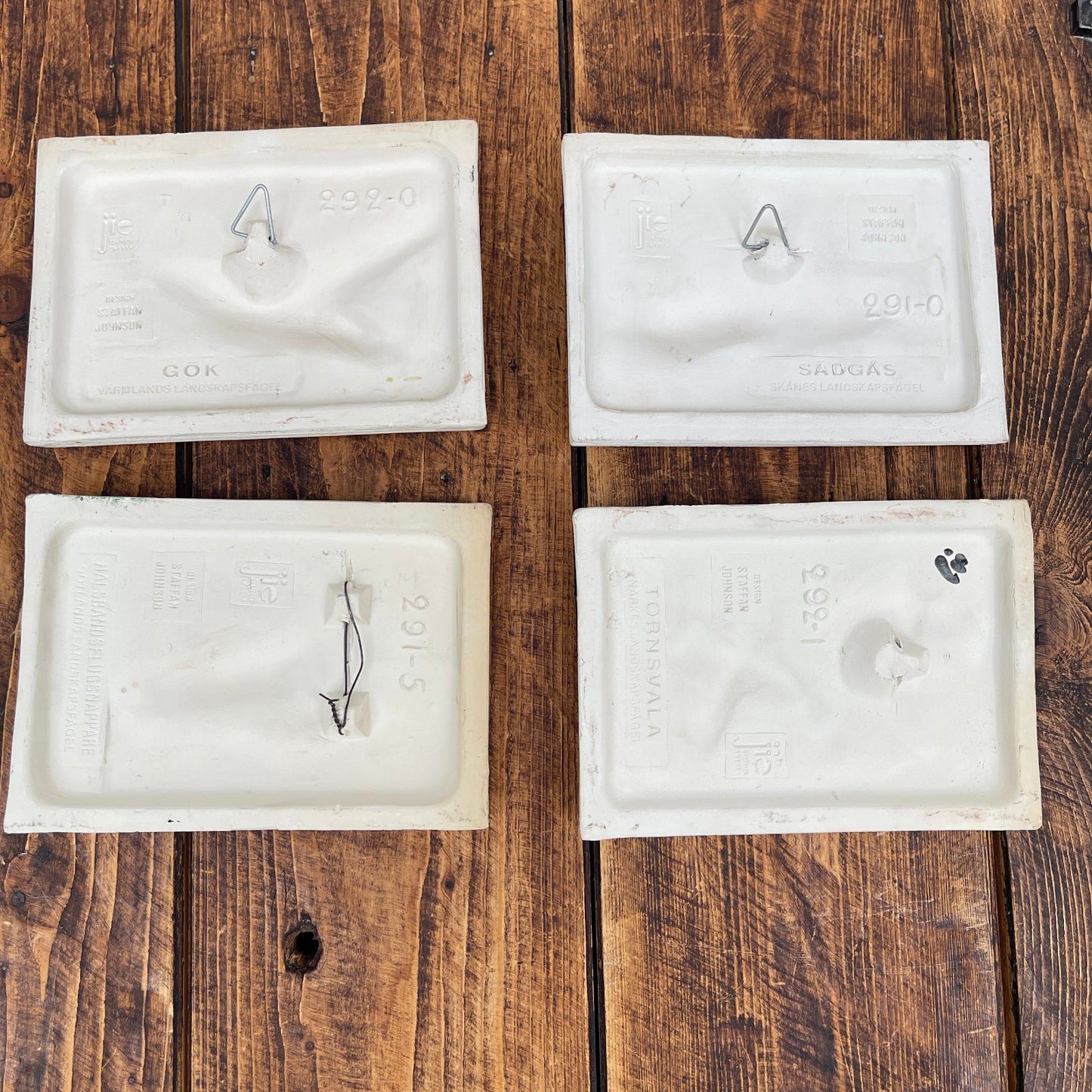 Four white plastic packets on a wooden surface